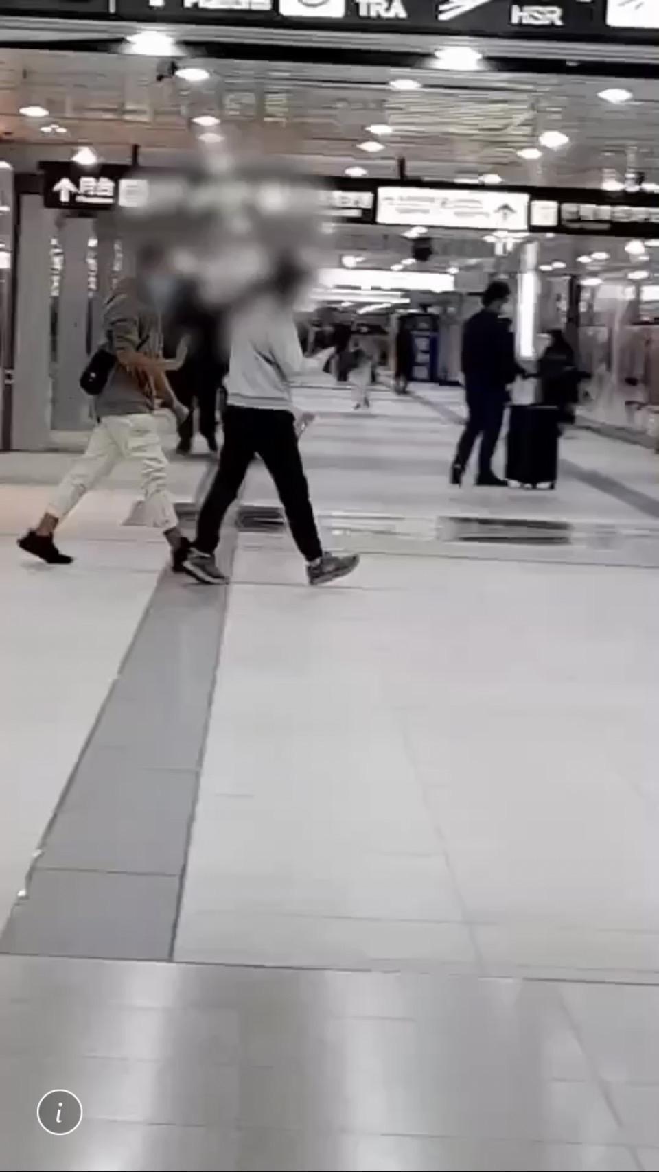 警方埋伏時,發現詹男(左一)在捷運聯通道四處找落單旅客搭訕要錢。(翻攝畫面)