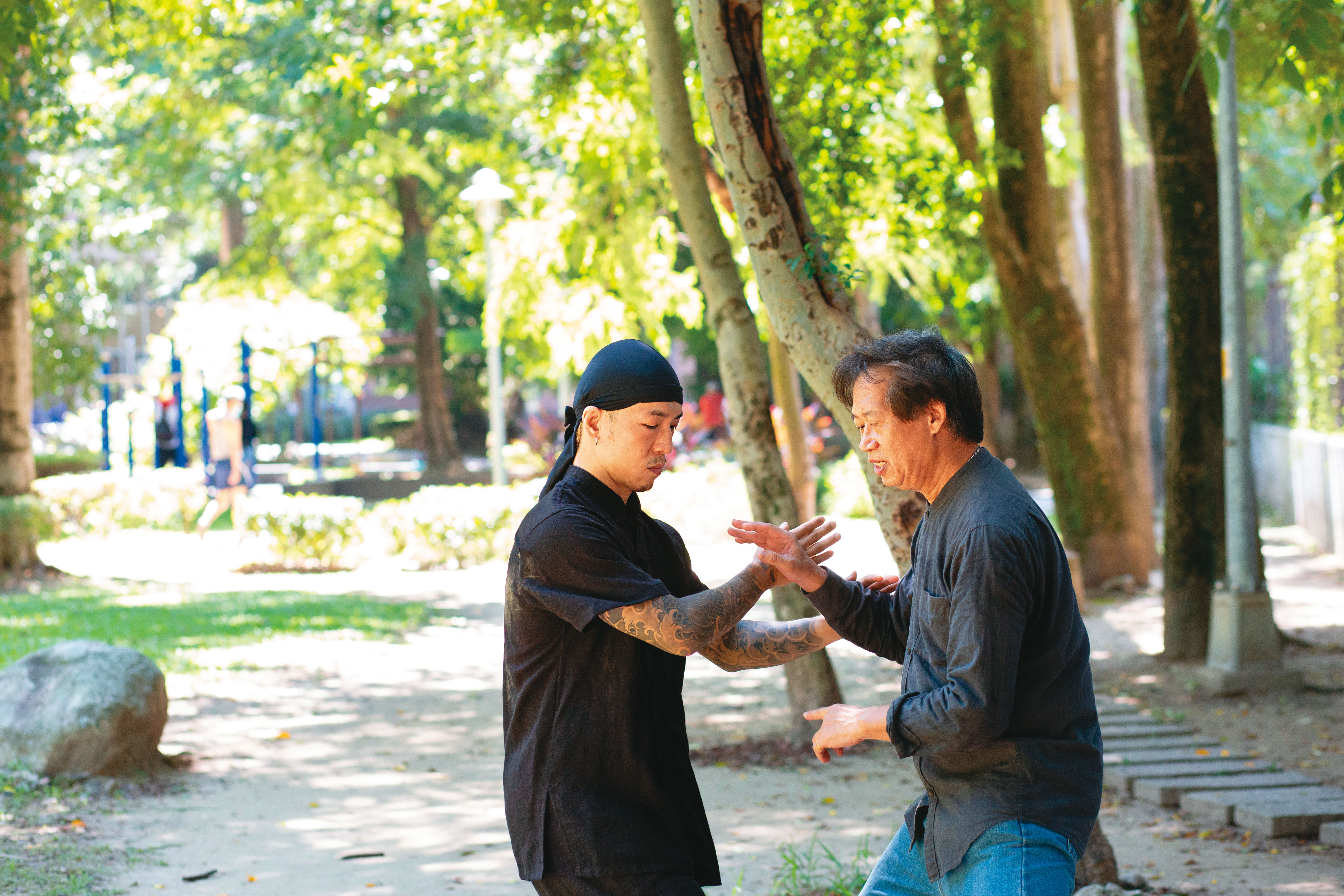 陳柏均（左）與太極拳老師王徵成（右）在公園練搭手。頸椎受傷後，太極拳教他在跳舞與格鬥間也要運氣，修身也修心。