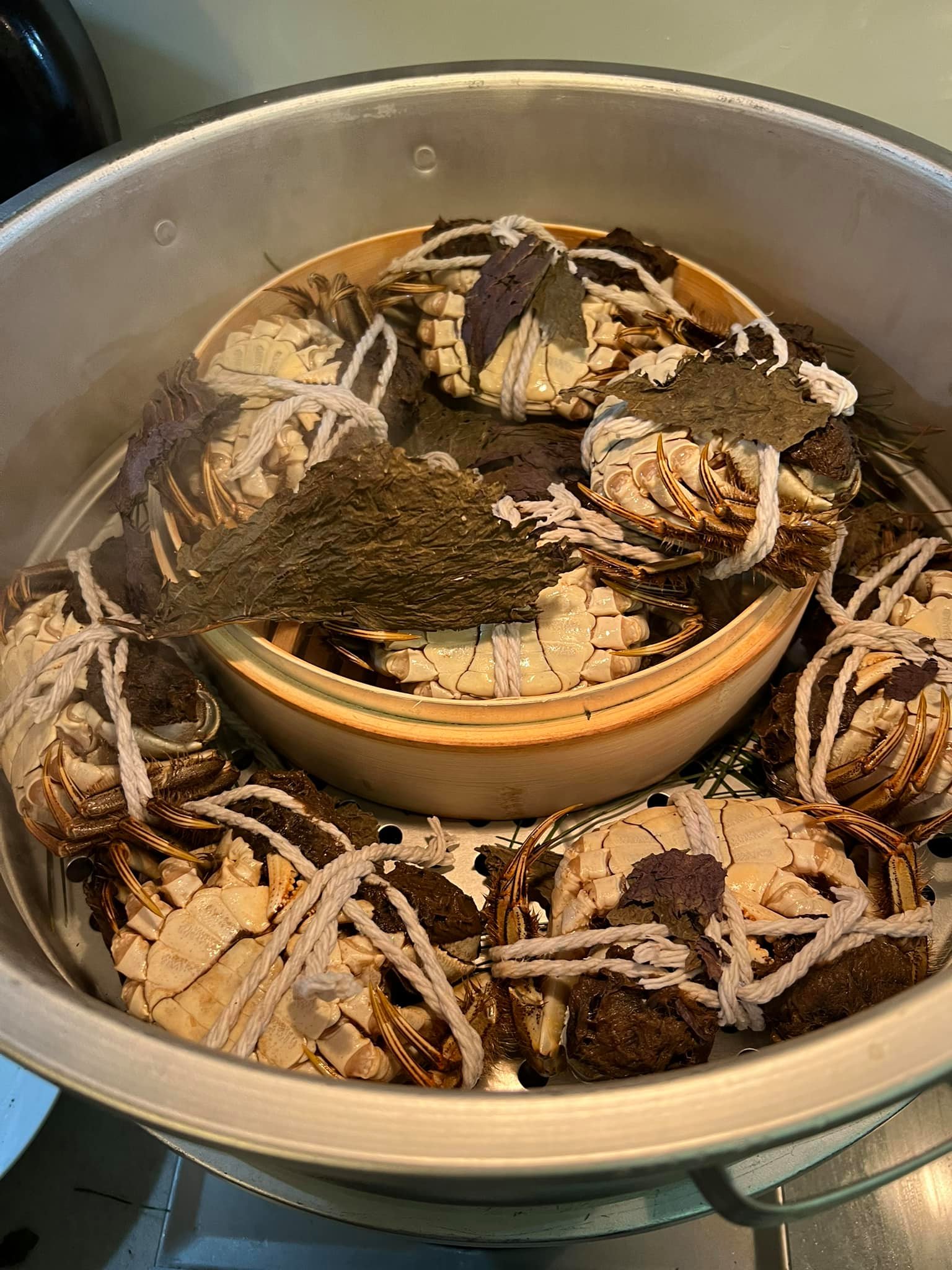 移走紫蘇葉,將蒸到剛好的大閘蟹取出。
