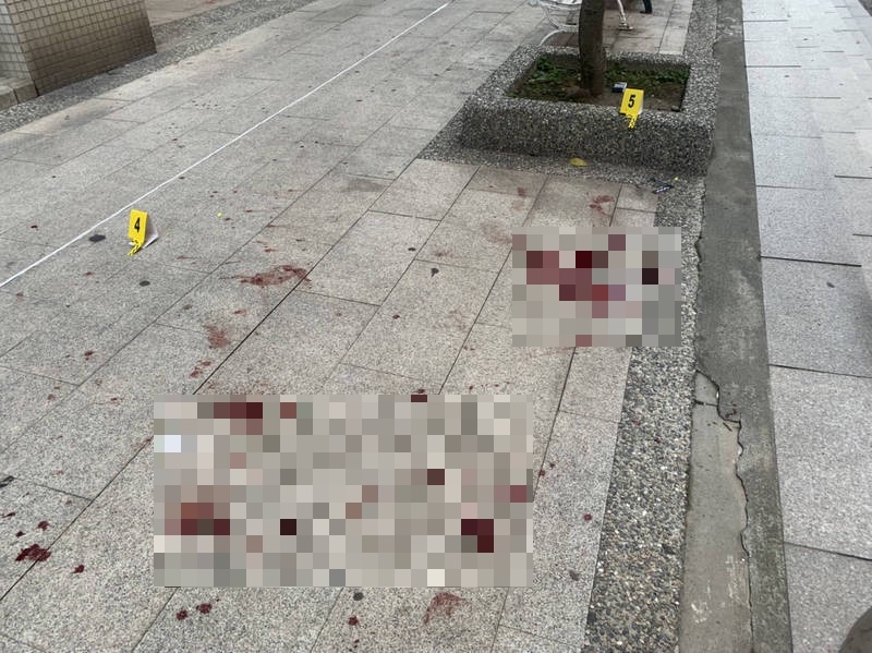 蔡姓店員遇刺後，奮勇奪刀，與對方扭打至店外，地上滿是血跡。（翻攝畫面）