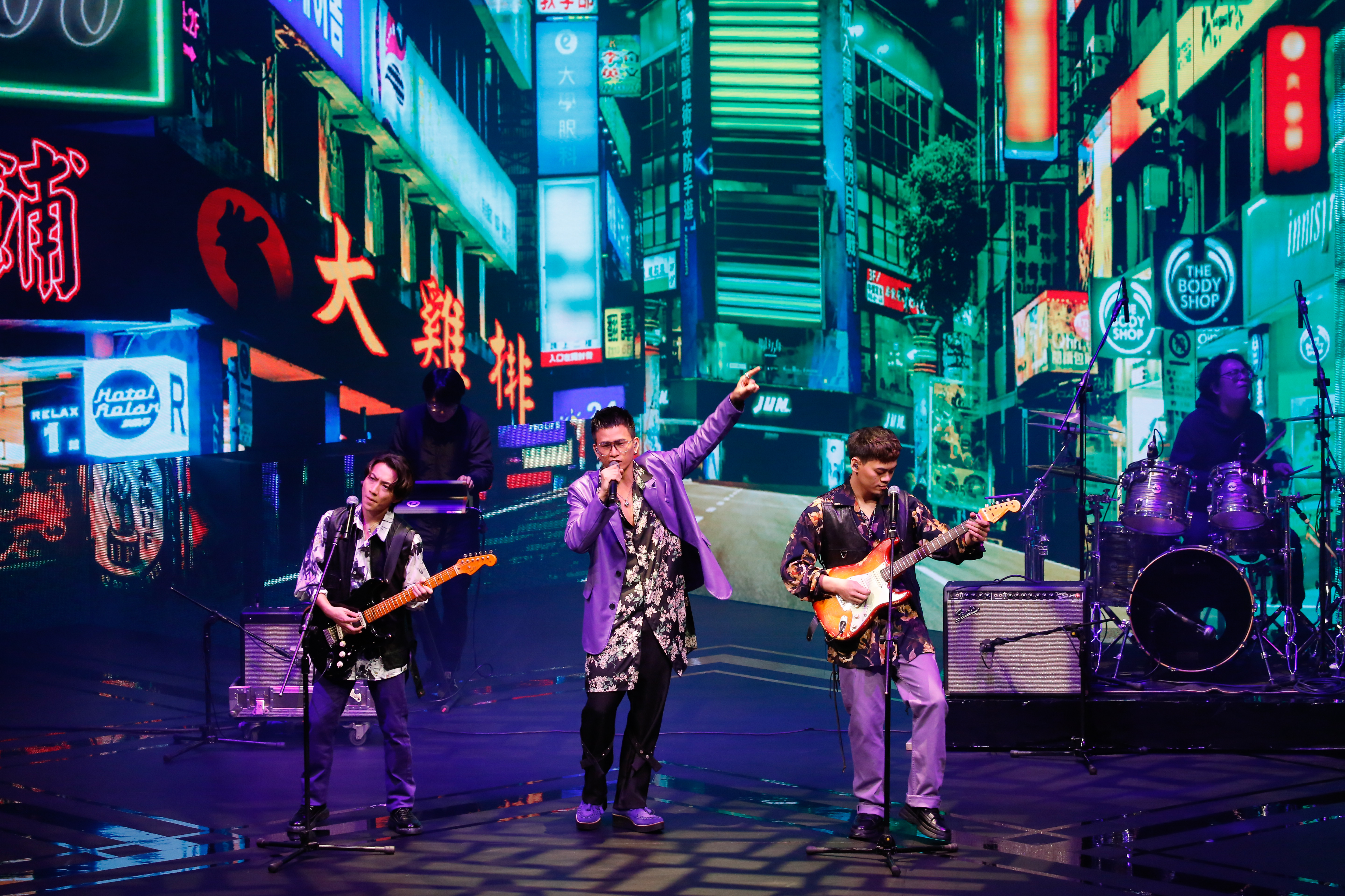 主唱阿斌身穿黑底花襯衫和紫色西裝，展現帥氣台味。