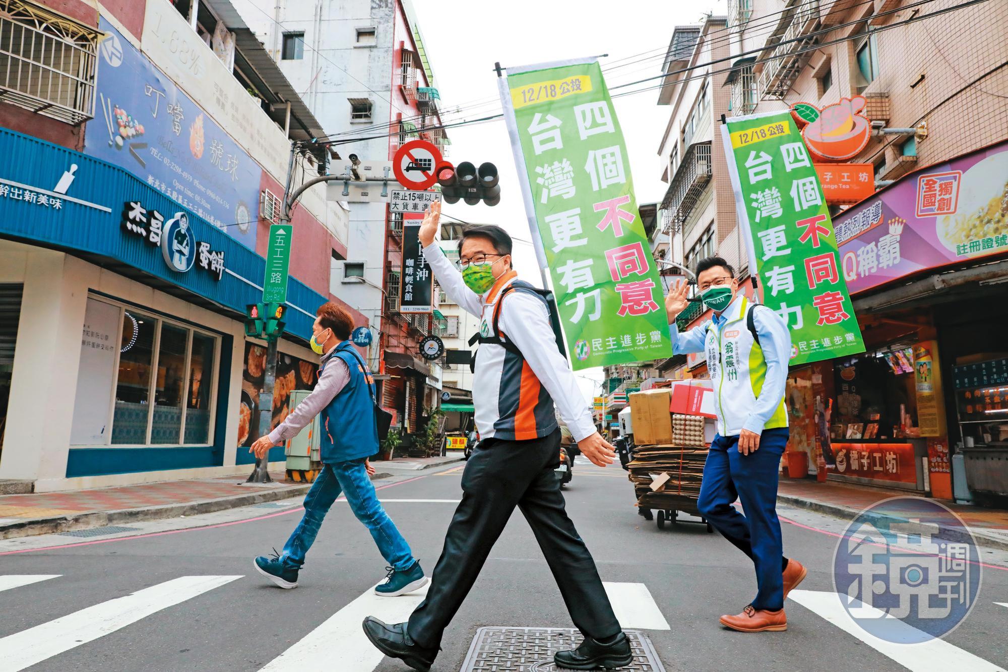 民進黨許多公職祭奇招宣傳公投,新北綠委吳秉叡(中)就率子弟兵翁震州(右)背工字旗徒步掃街。