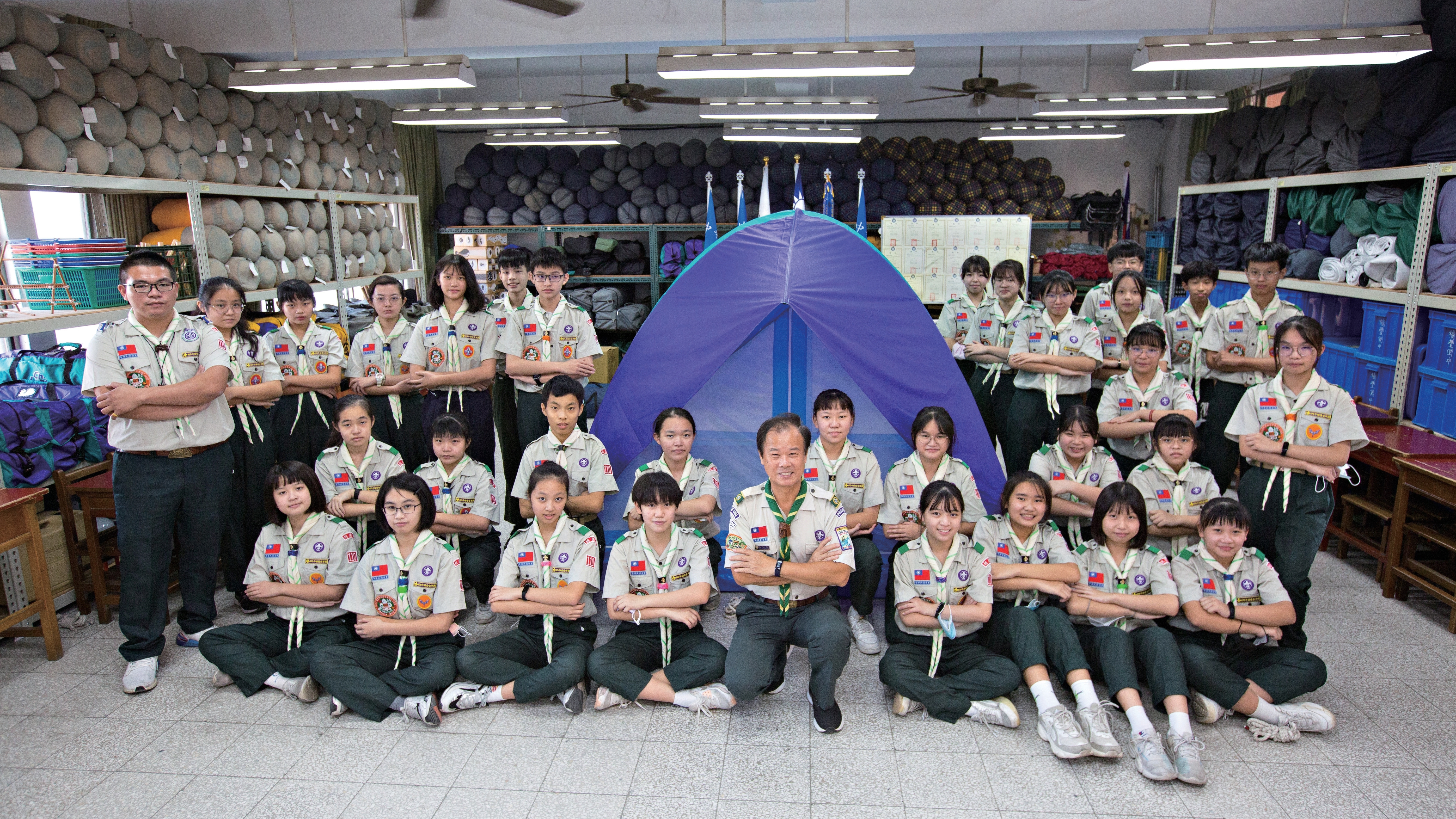 桃園市童軍會總幹事徐松芳與福豐國中童軍團一起比出象徵「和平」的姿勢。