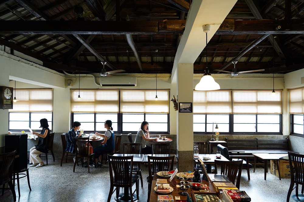 「書店喫茶一二三亭」裡木構屋架為日治時期建造，下方水泥柱及磨石子為戰後增建，看得到不同年代的痕跡。