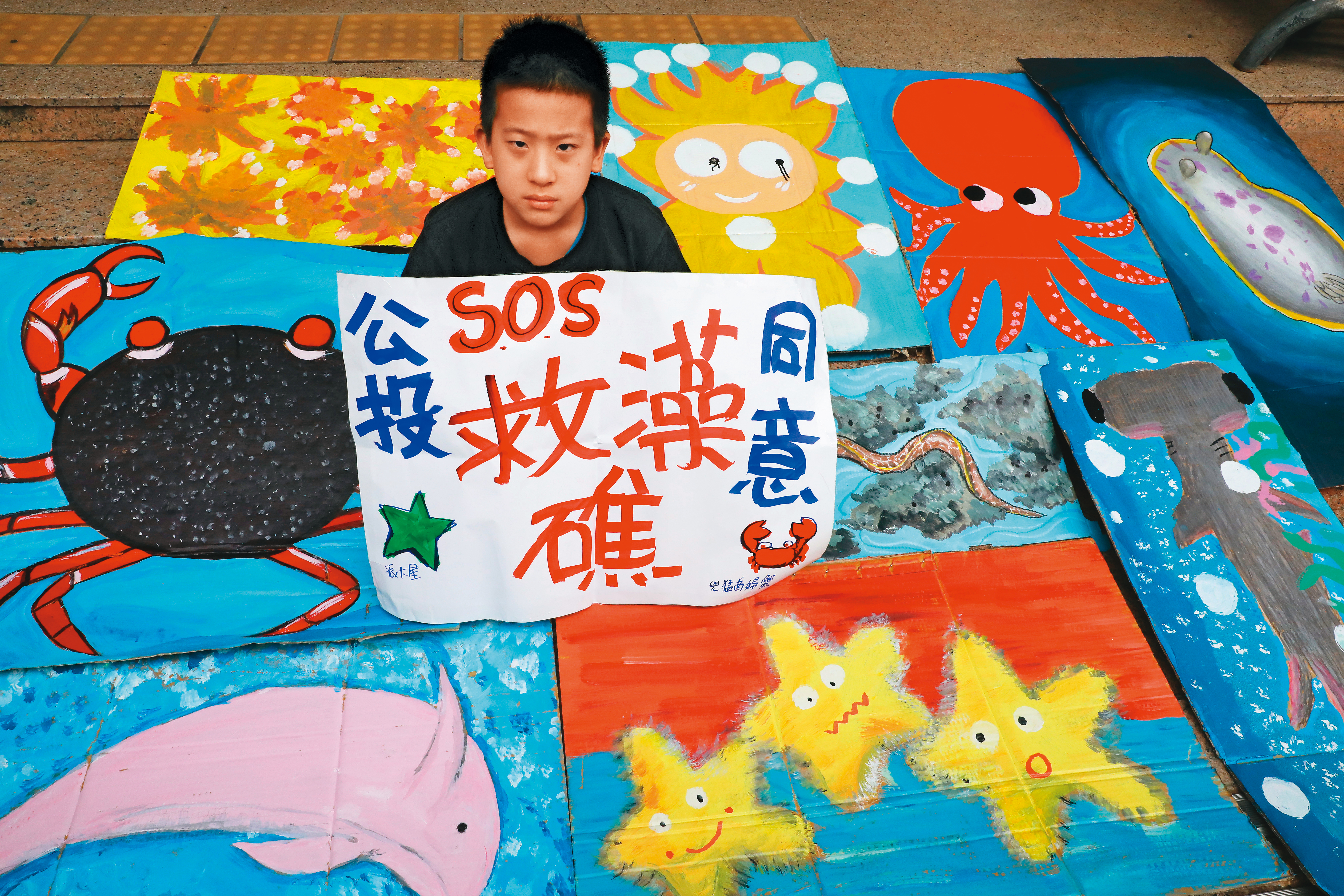 圖為藻礁公投推動聯盟12月5日於立院外舉行記者會，小學生展示藻礁生態系中各種生物的繪圖作品。
