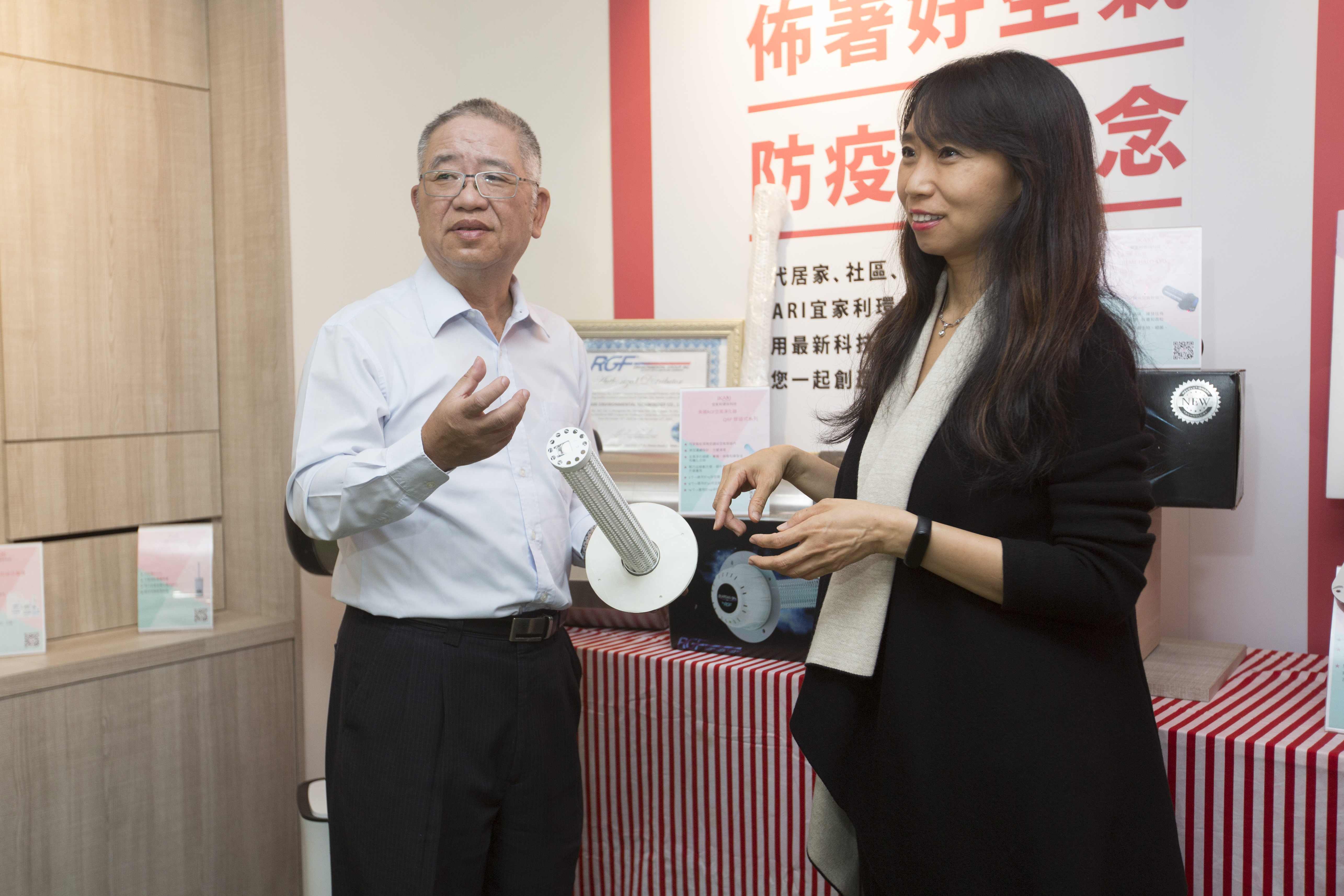 黃昭贊與子公司宜家利環保科技總經理周郁菁介紹防疫產品。