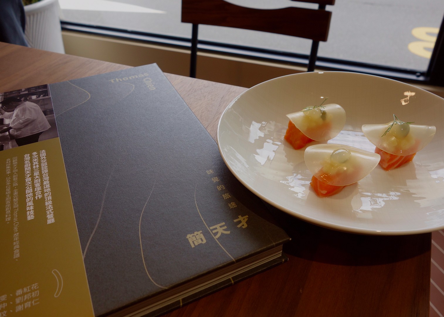 「法餐南霸天」主廚簡天才出版第一本個人著作《Thomas Chien ─ 味覺的旅途》。在新書發表會當天，他端出在書中收錄食譜的「諾曼第風味蘋果煙燻鮭魚」冷菜作為開場。