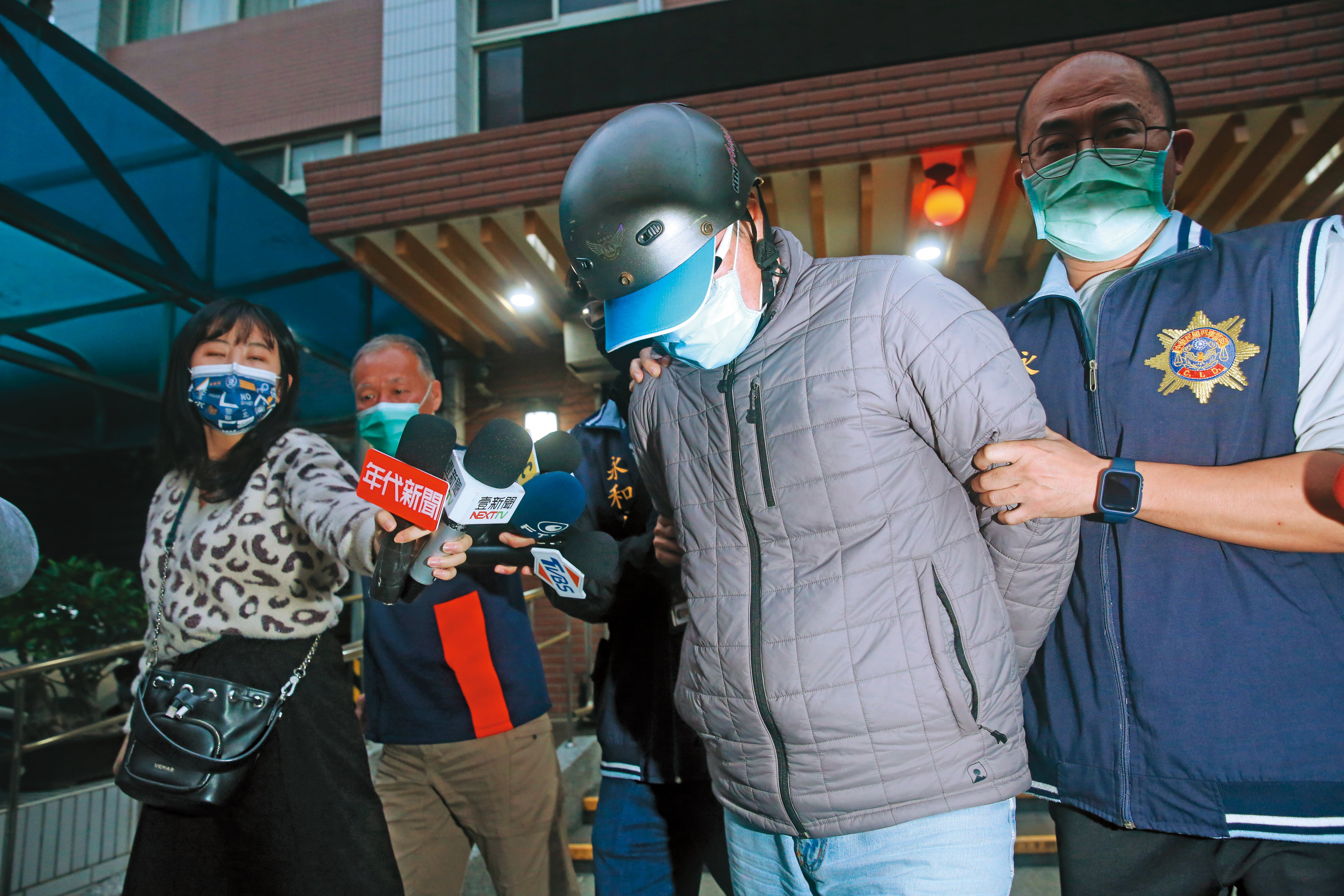 面對媒體詢問殺父動機，符男（右2）始終保持沉默。