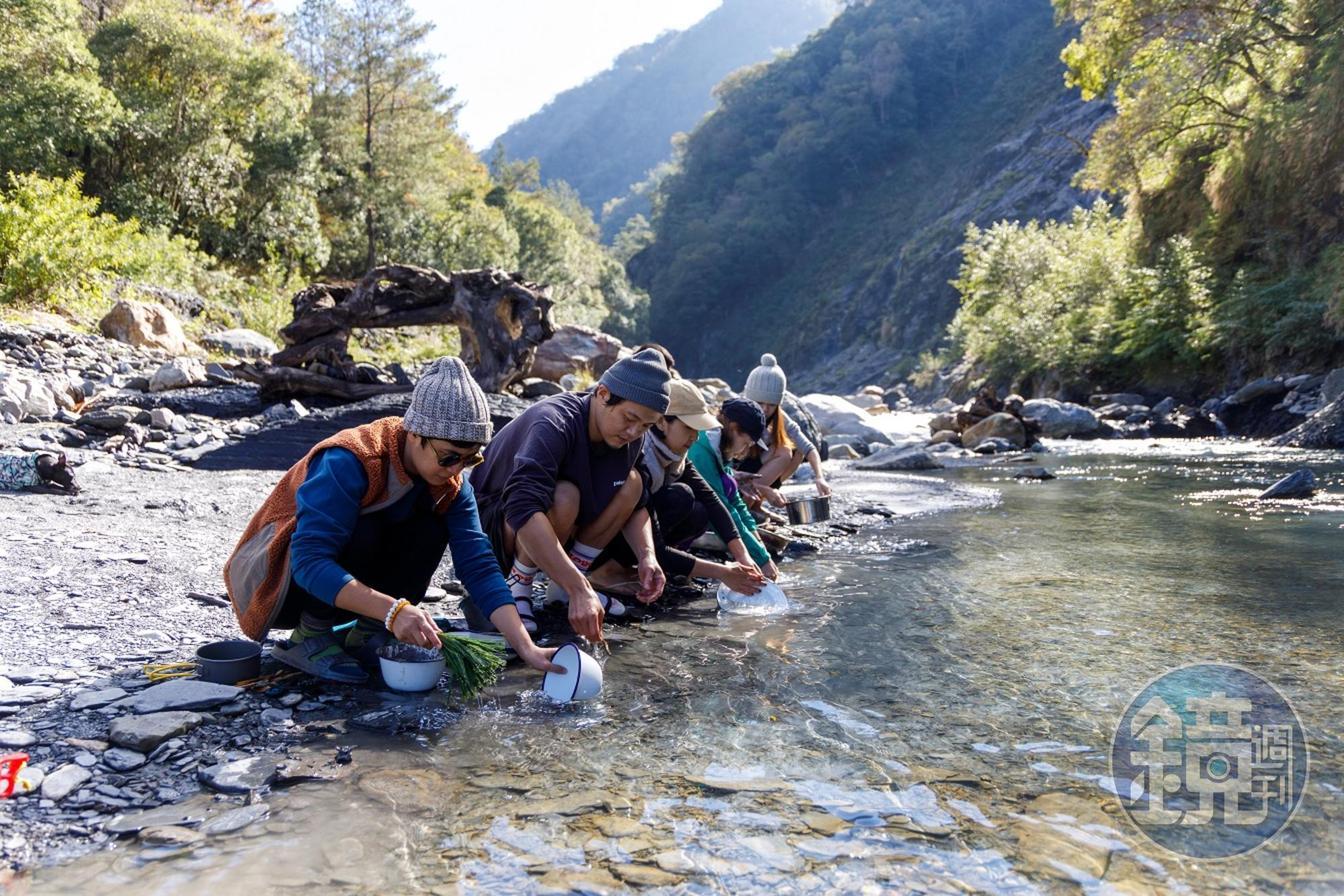 擦拭過的碗盤拿到溪邊，簡單的沖洗。