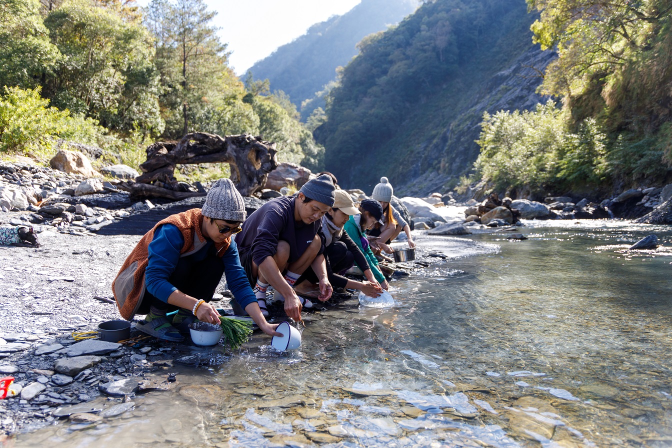 擦拭過的碗盤拿到溪邊，簡單的沖洗。