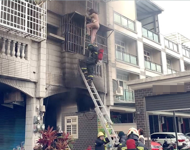 彰化縣田中鎮發生民宅火警，消防員架起鋁梯，從三樓救出屋主太太。（消防局提供）