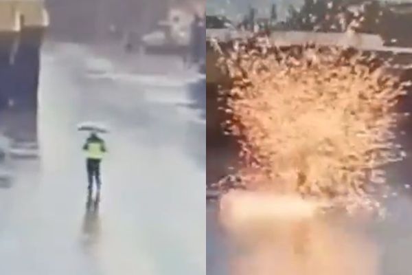 印尼一名保全昨（26日）撐著雨傘在大雨中巡視工廠時，意外遭閃電擊中。（翻攝自推特）