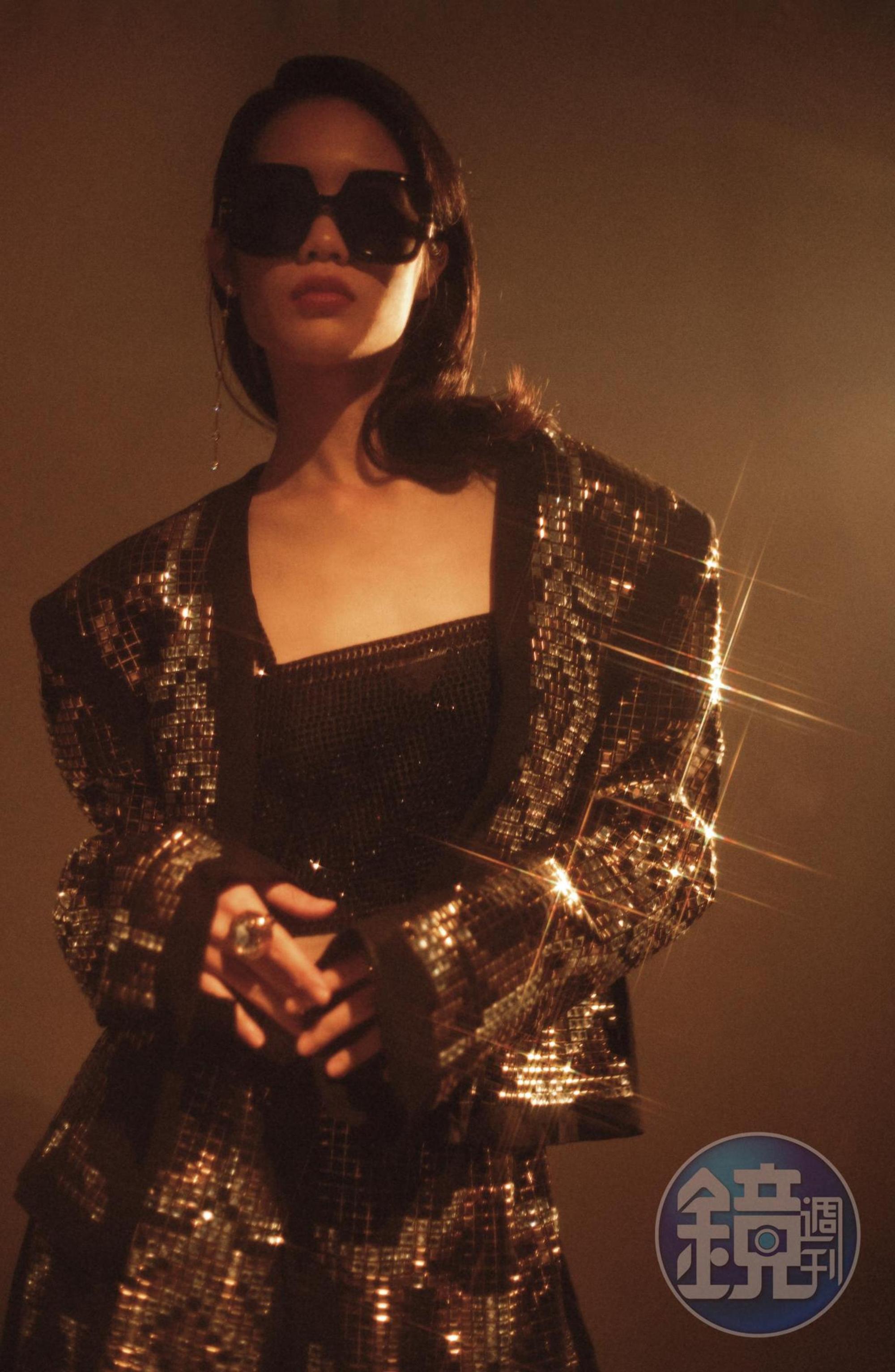 金屬鉚釘外套 價格店洽 by BALMAIN；水晶刺繡背心 NT$71,000 by PRADA；金屬鉚釘裝飾鬆緊長褲 價格店洽by BALMAIN；棕色玳瑁花紋正方形太陽眼鏡 NT$16,400 by DIOR；Constella穿孔耳環 NT$5,490 by SWAROVSKI；水晶戒指 NT$17,500 by VERSACE。