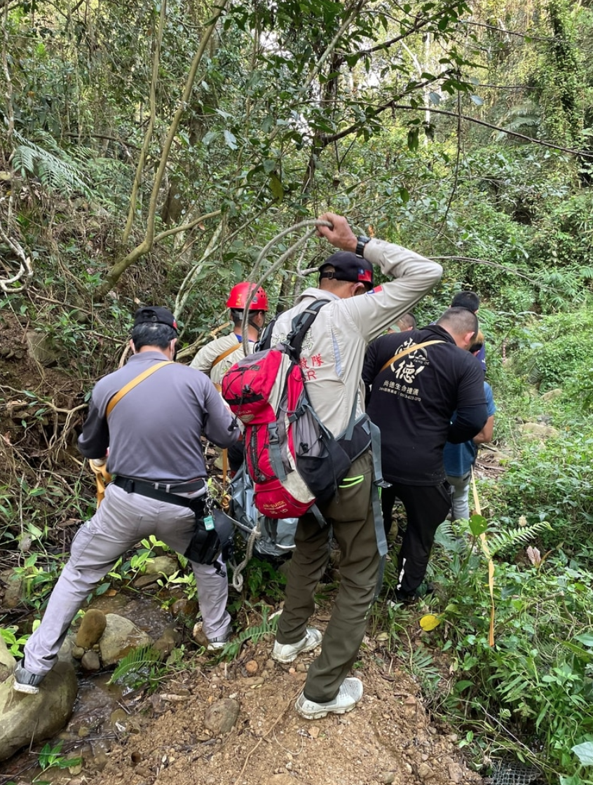 死亡的范姓男子遺體被搜救隊搬運下山。(翻攝畫面)