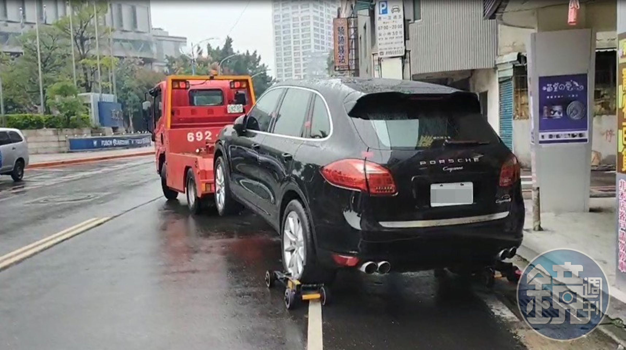 新北分署執行人員在新莊區路邊收費停車格查封許姓男子的保時捷，準備拖吊回保管場。（翻攝畫面）