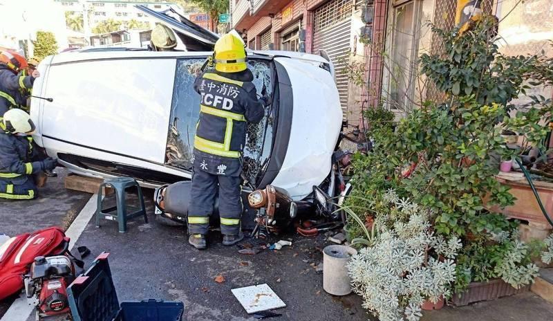 一輛自小客車今天下午1點多行經太平大興路時,疑似超車不慎撞上民宅翻覆,大批消防人員獲報到場搶救。(消防局提供)