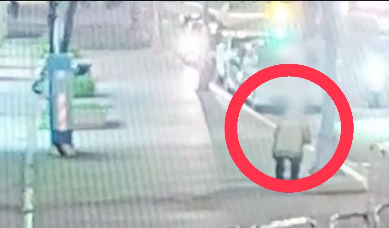 警方調閱監視器，發現古男（紅圈處）在交通號誌桿上塗鴉，事證明確。（翻攝畫面）