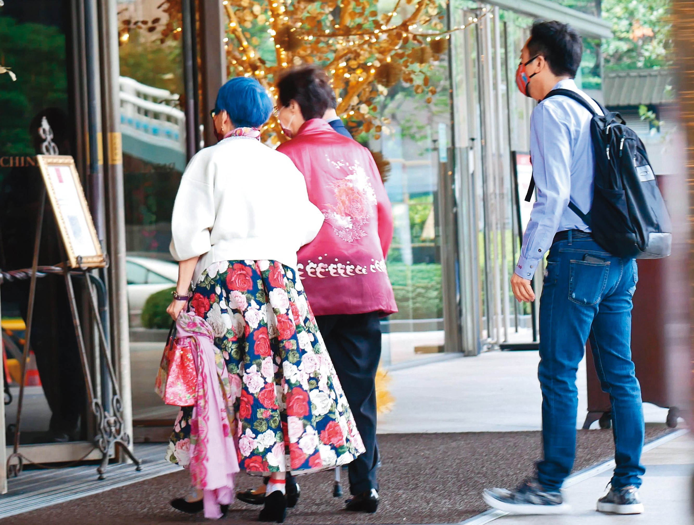 11：57 哈林（右）跟在後面，護送母親（中）和張小燕進入君品酒店頤宮餐廳用餐。