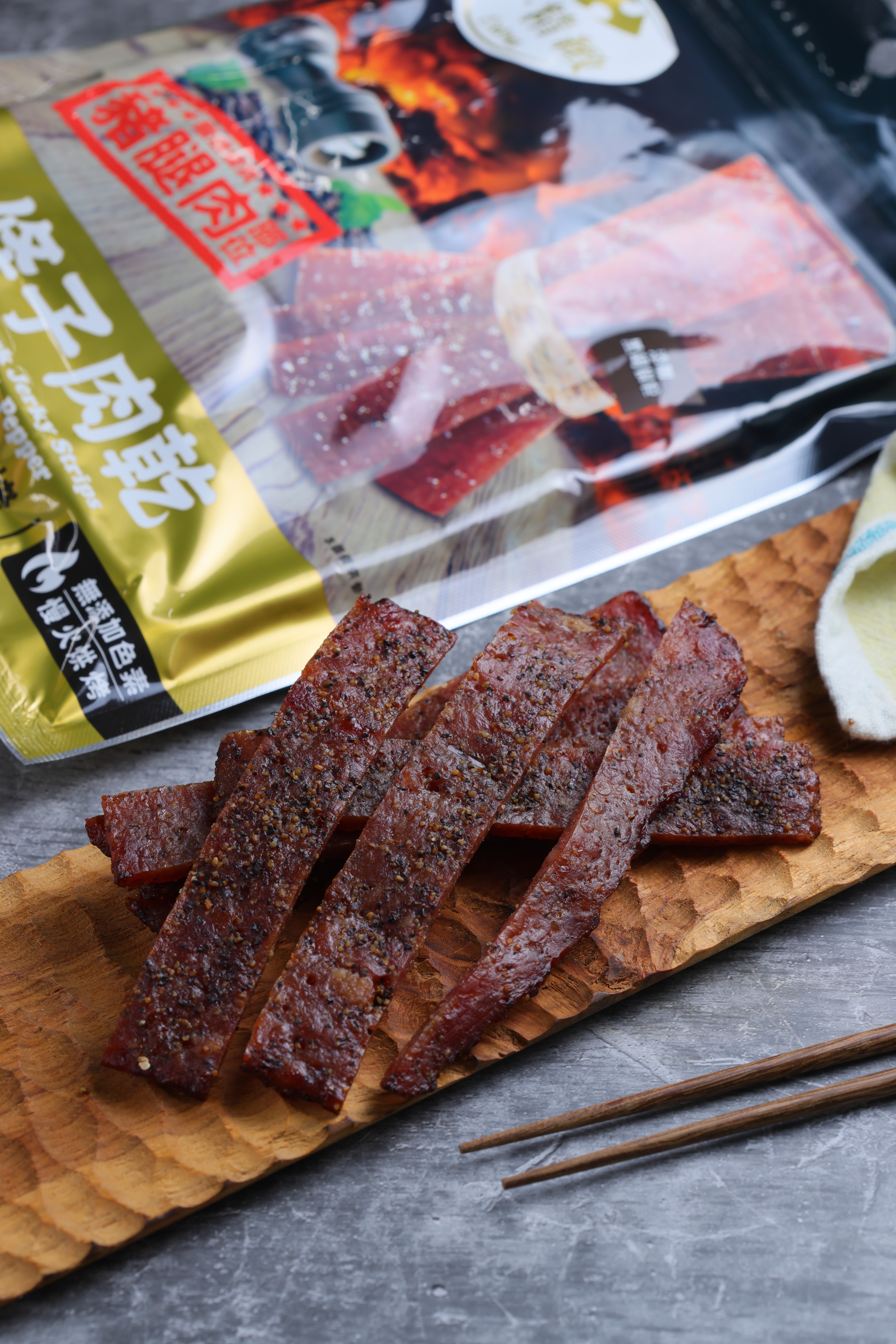 家樂福自有品牌的「黑胡椒炭燒條子肉乾」以豬腿肉製成，甜中帶點胡椒的刺激，配電視頗涮嘴。（125元／包）