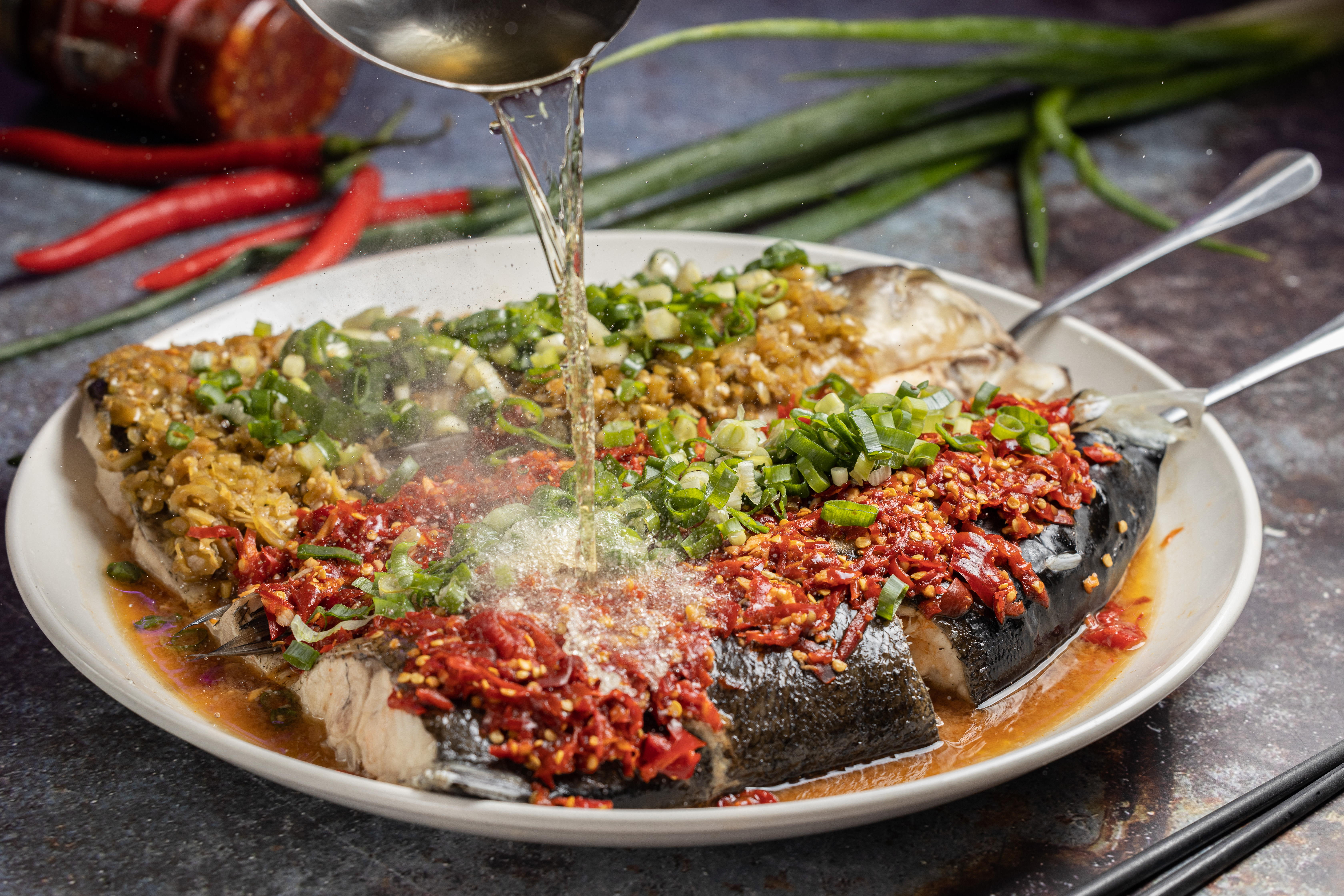 「雙色剁椒魚頭」用自製的青、紅兩種剁椒蒸大頭鰱，肉質幼細帶膠，鮮爽帶酸的辣度還可客製。（900元／全份，550元／半份，需前一日預訂）