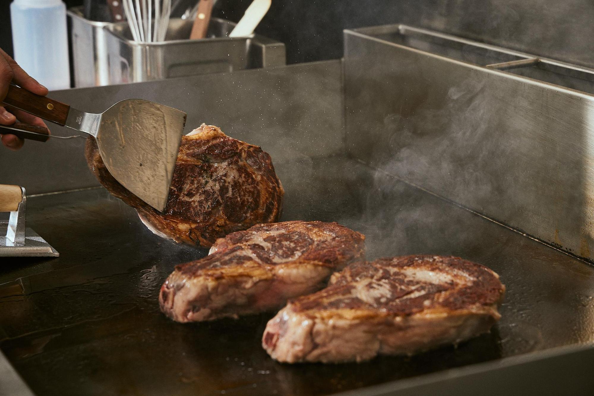 被命名為「肉年菜」的「厚切炭烤丁骨牛排」，厚切5公分，分量驚人。（RÒU BY T-HAM提供）