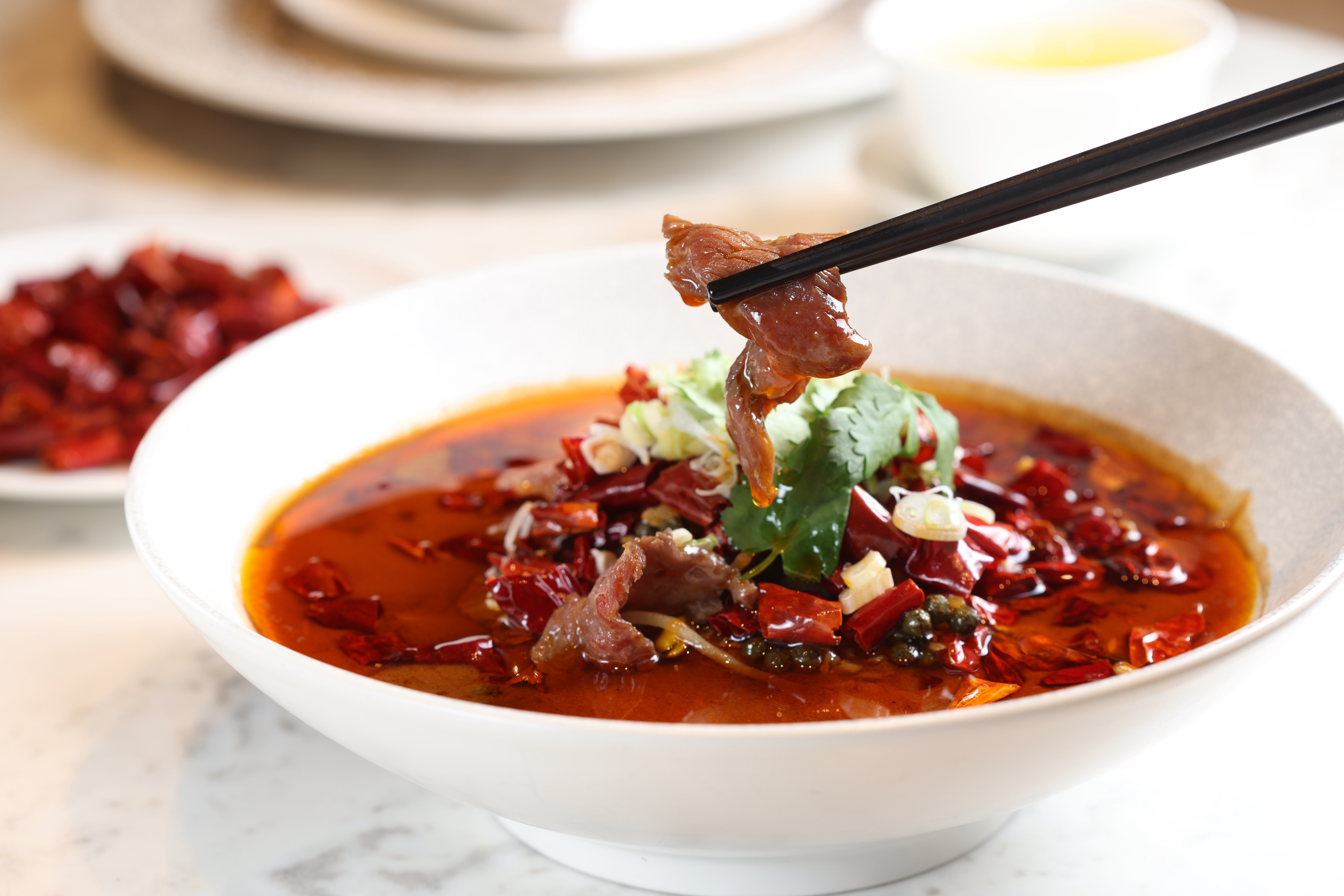 「水煮牛」湯色濃豔，喝來順口不嗆。選用台灣溫體牛，肉質滑嫩，咬個幾下就滑入喉裡。（580元／份）