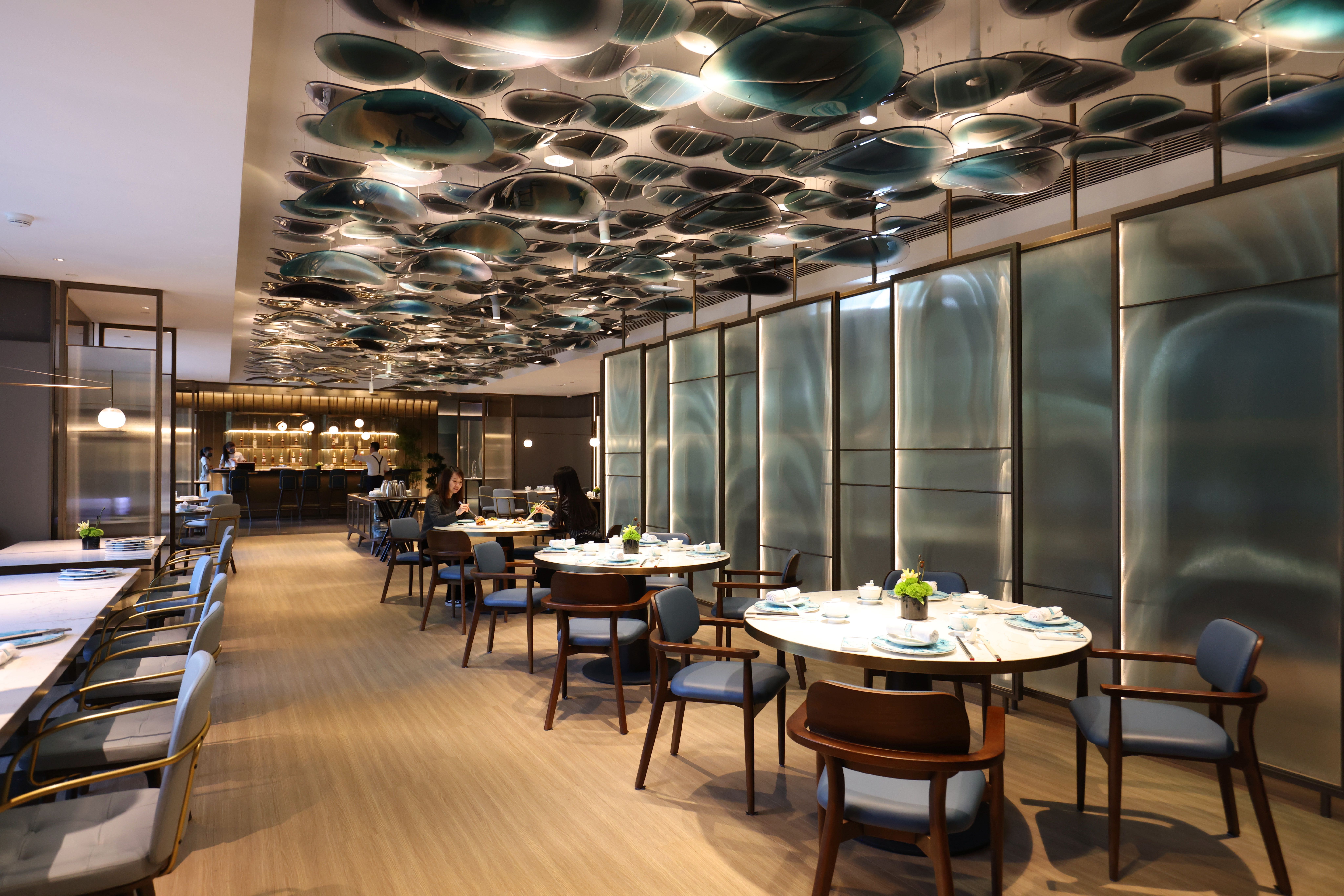 餐廳內裝飾藍色圓潤造景，呼應飯店的海洋意象主軸。