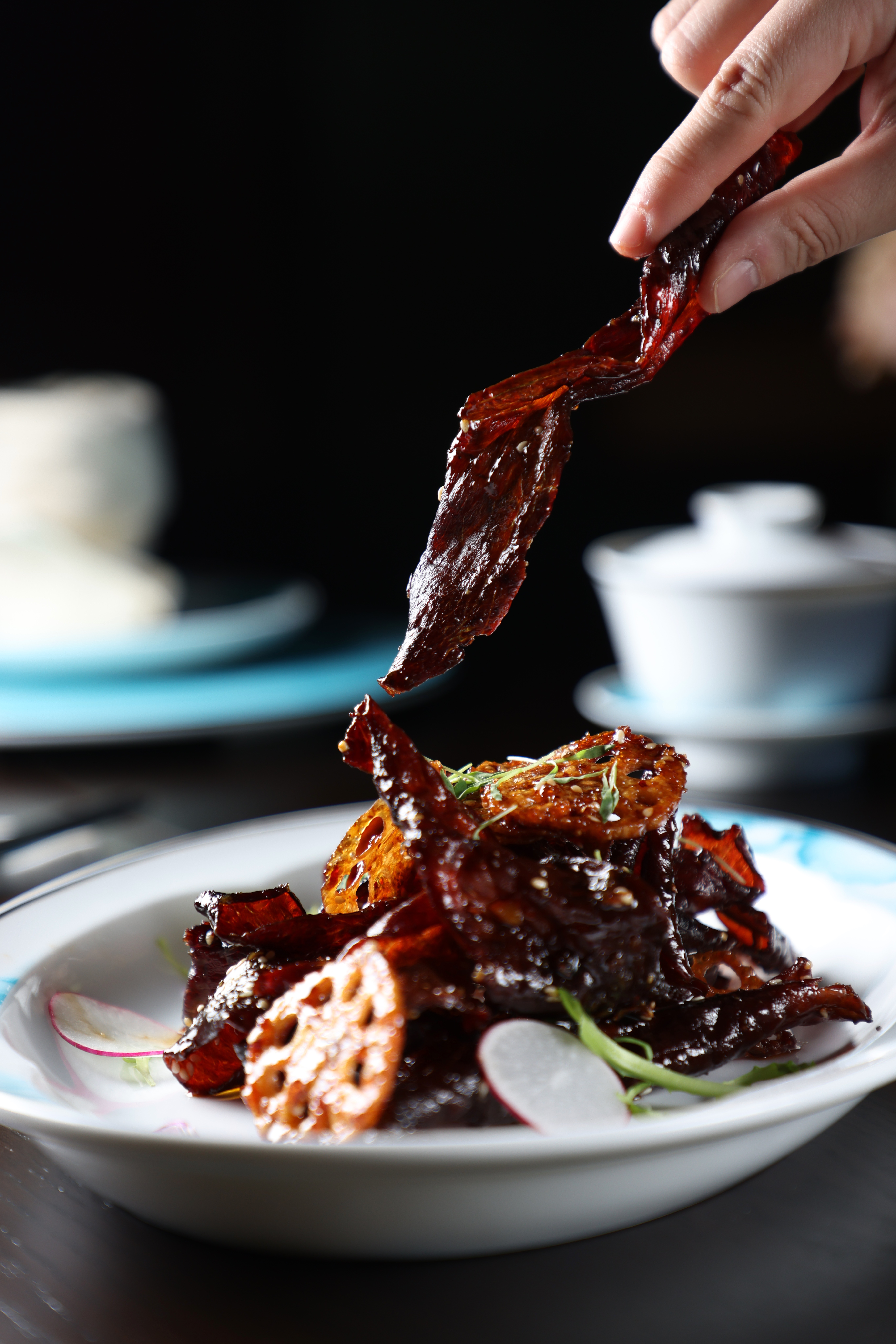 「脆藕燈影牛肉」抹上花椒油、烘乾一晚的薄切牛腿肉，以冷油炸得酥香，再裹上辣椒油、蒜、糖和醬油特調醬汁。（480元／份）