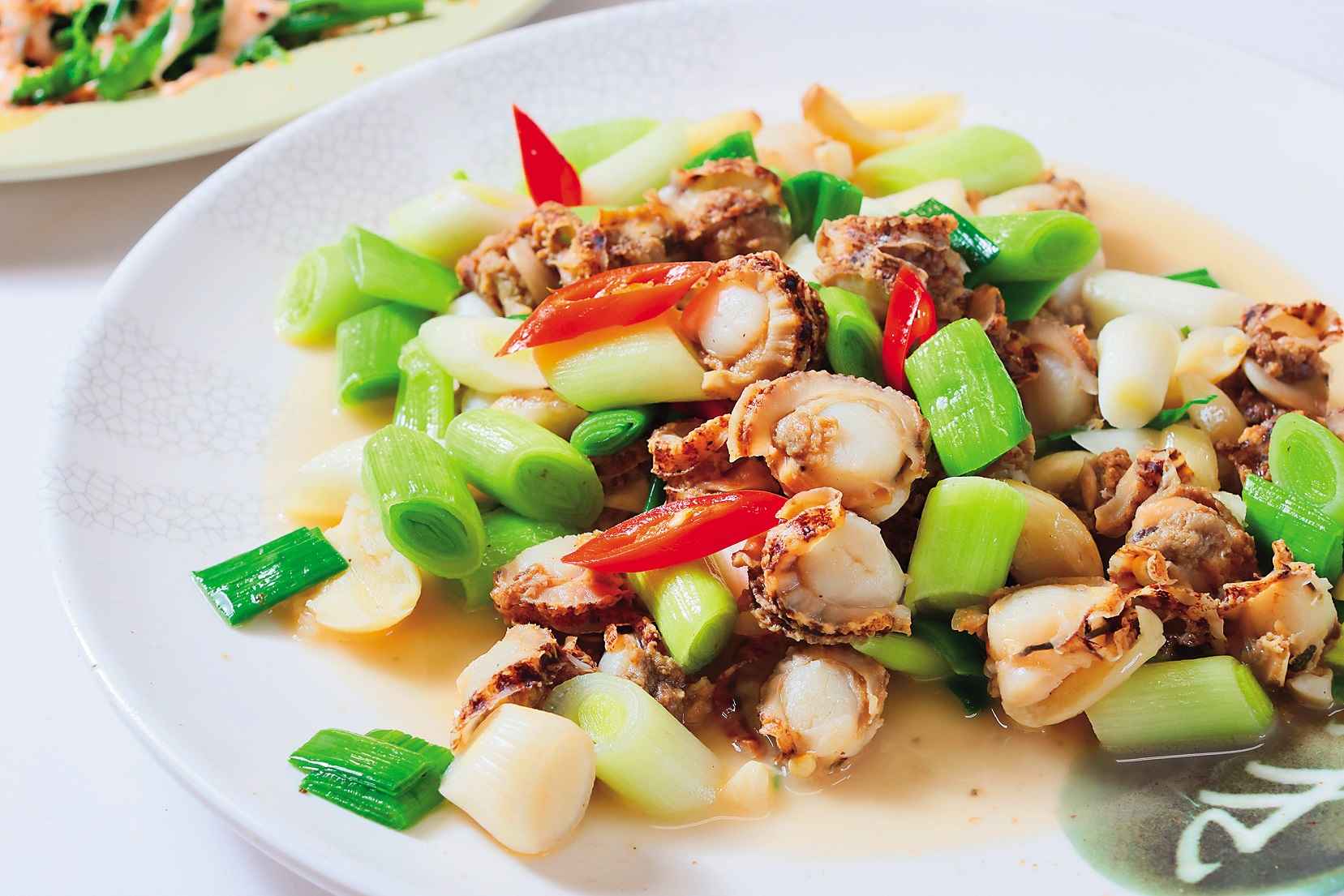 肉質Q彈的「花貝炒蒜苗」。（500元／份） 