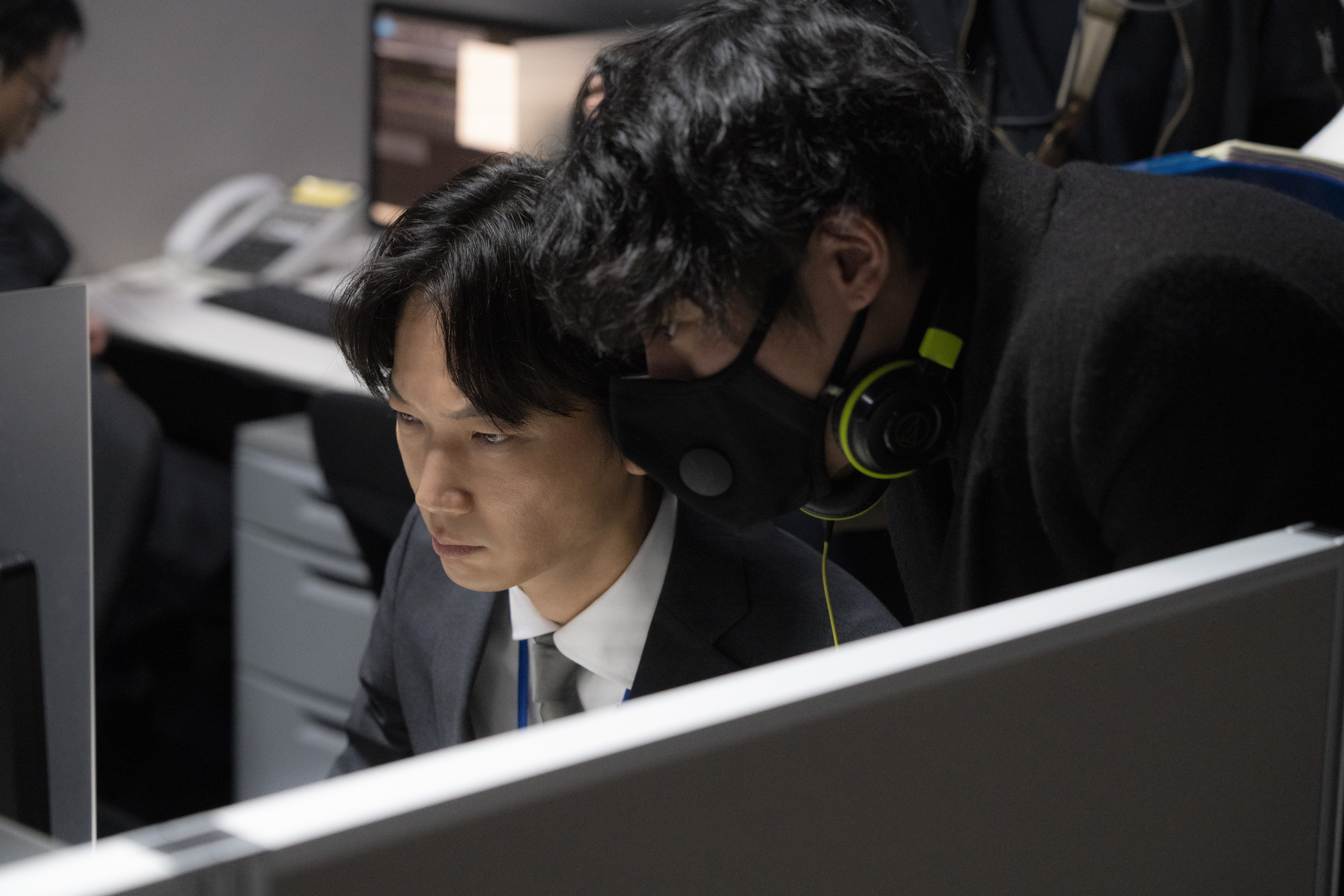 綾野剛(左)在拍攝內閣情報調查室布景戲時,4天不吃不喝,敬業精神讓藤井道人導演讚嘆不已。(Netflix提供)