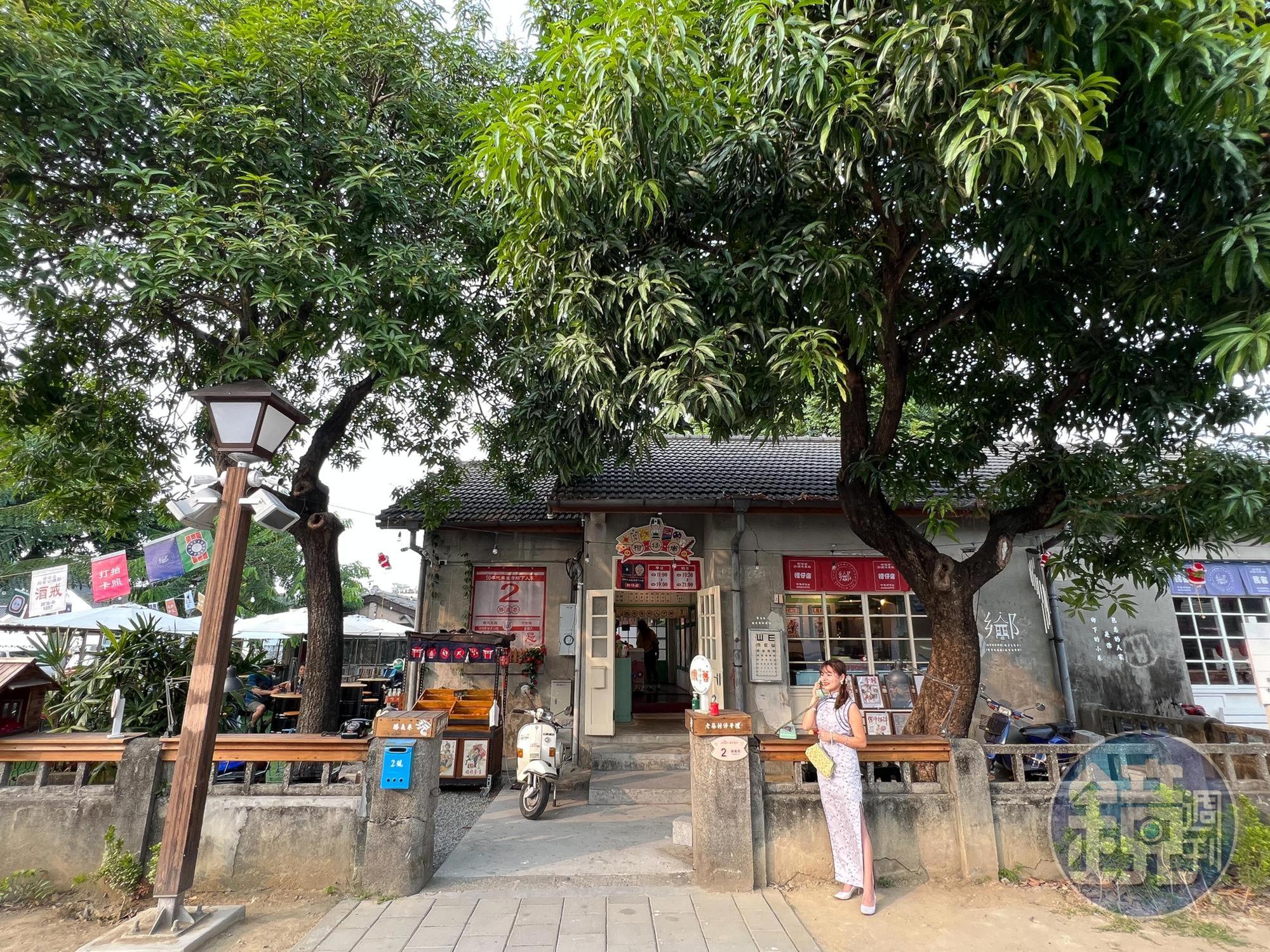 大樹下的「50年代屏東市鄉 下人家柑仔店」,外頭停放一輛瀟灑的偉士牌機車。
