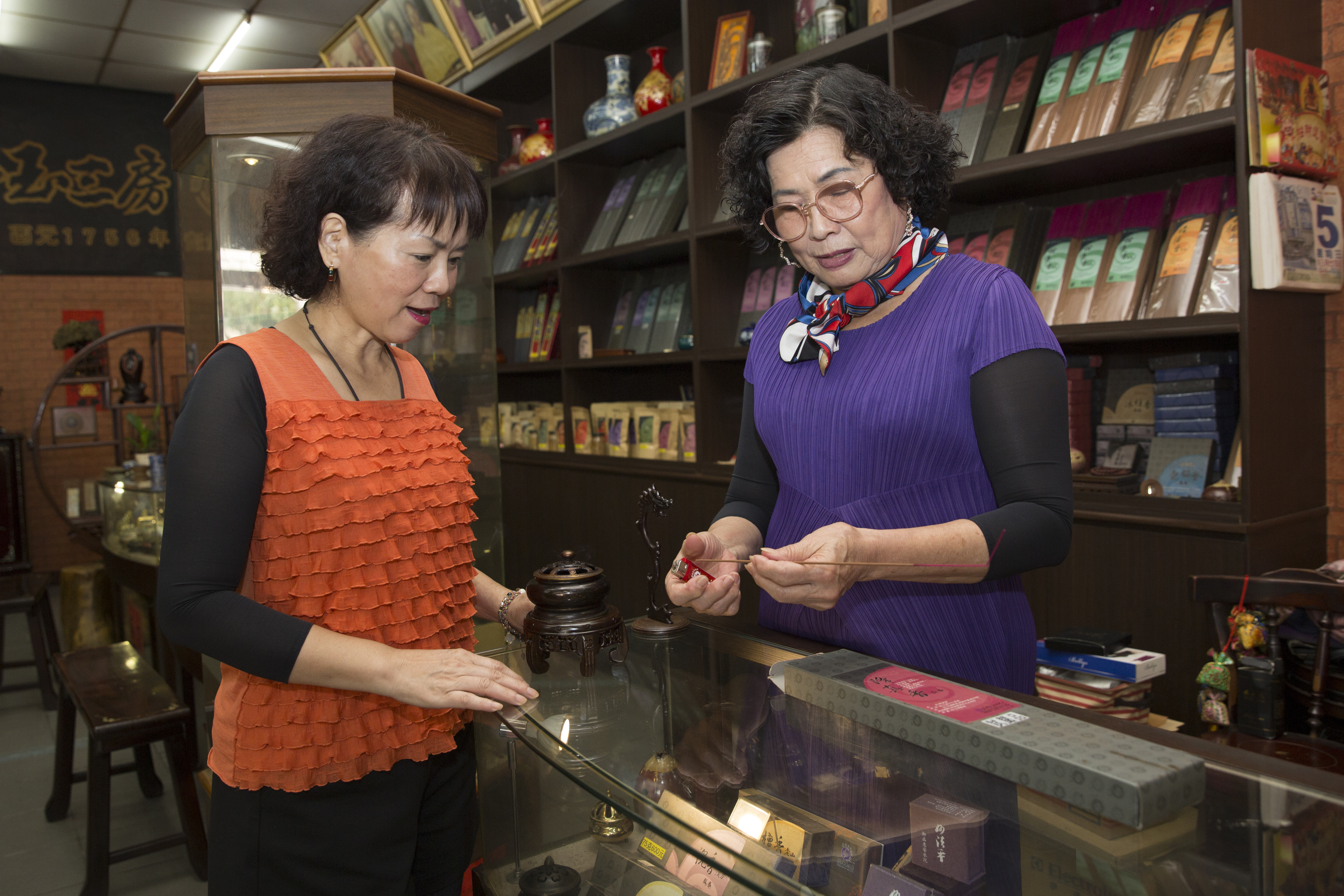 只要客人進店，第7代老闆娘洪寶真（右）一定點香讓客人試聞，詳細解釋何謂中藥養生香。