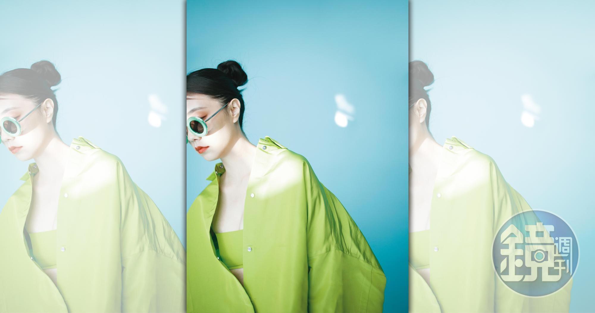 螢光綠外套式羅緞襯衫，NT$88,500 by VALENTINO；螢光綠上衣，NT$23,000 by VALENTINO；綠色圓形太陽眼鏡，NT$13,550 by LOEWE。