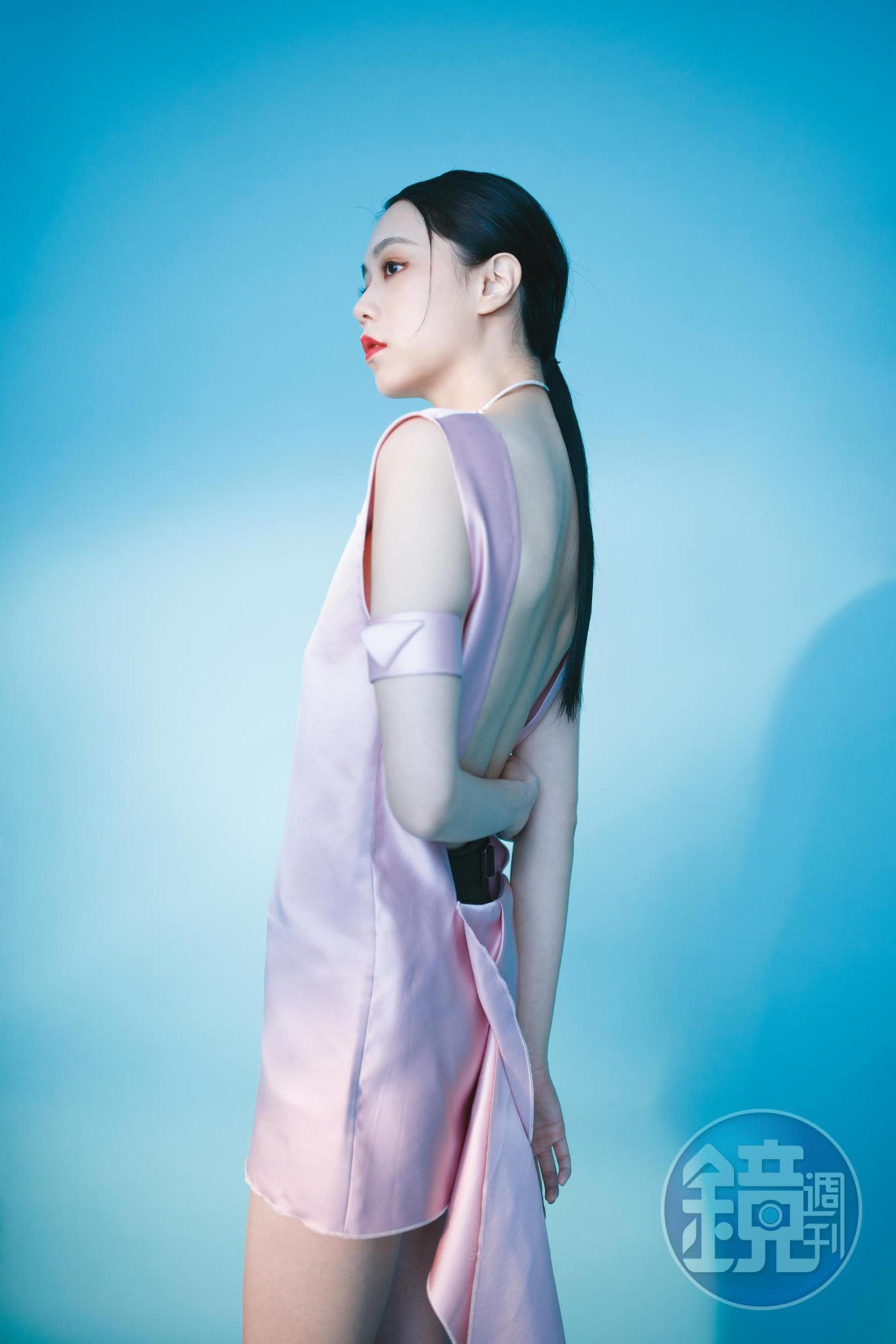 緞面拖尾裙襬洋裝，價格店洽 by PRADA；針織內搭褲，價格店洽 by PRADA；開口珍珠項圈，NT$15,500 by APM MONACO；緞面手臂環，價格店洽 by PRADA。