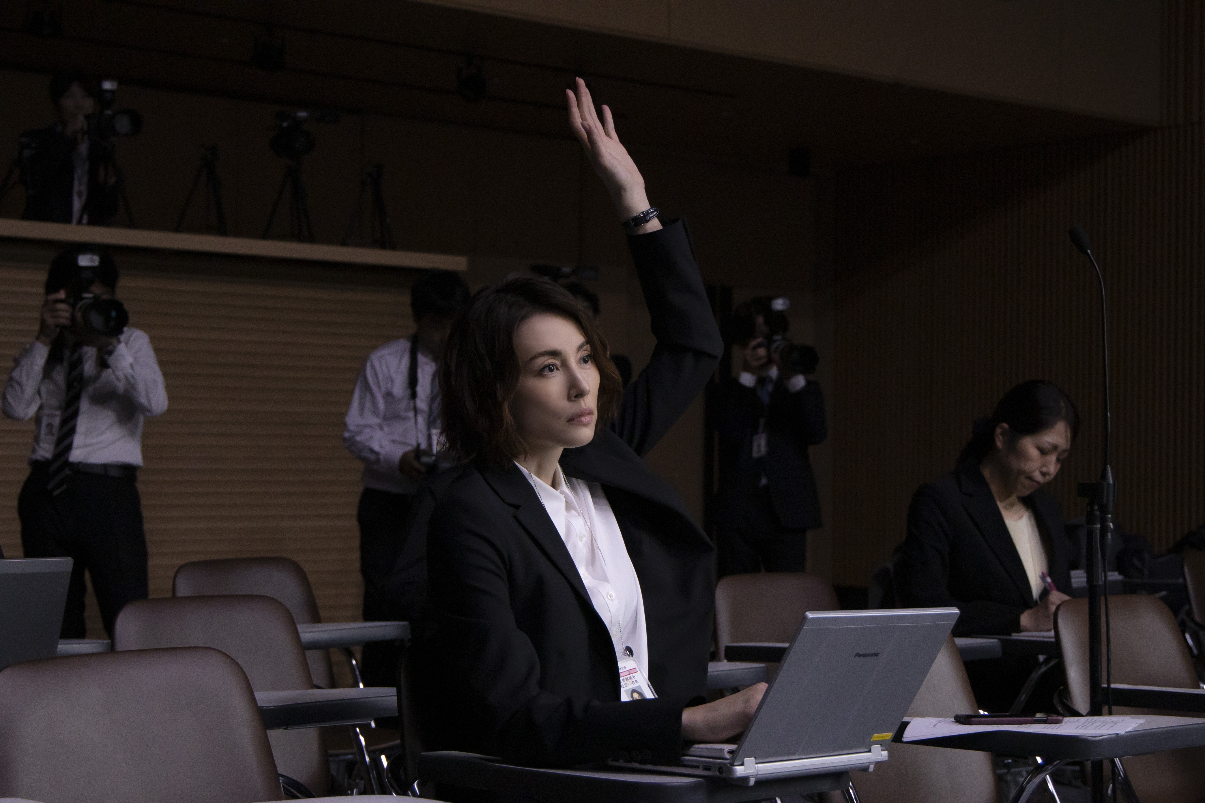 劇中米倉涼子出席政府內閣例行記者會時,不畏當權積極提出疑問。(Netflix提供)