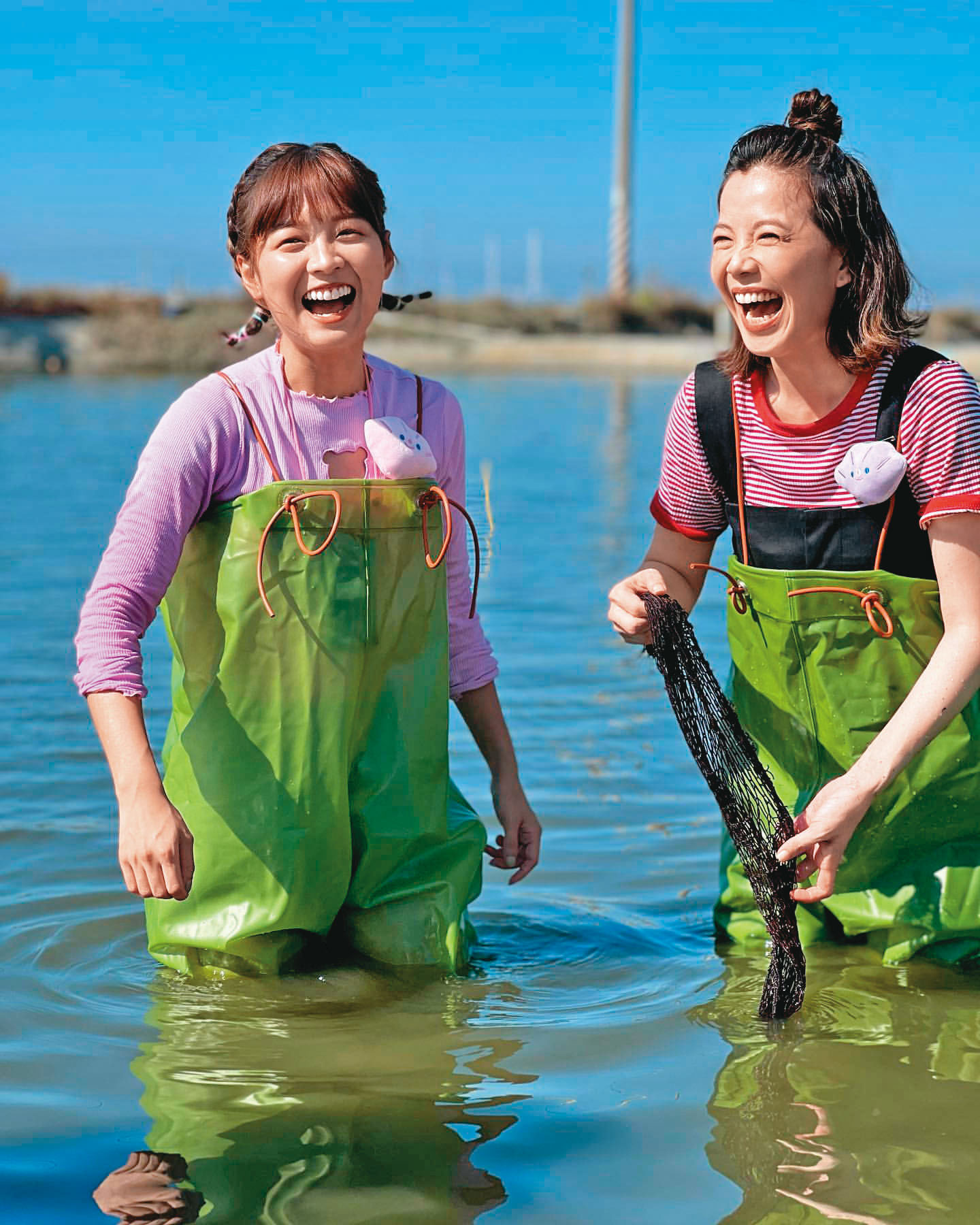 近日廖苡喬(右)參加民視八大《綜藝新時代》外景節目,帶大家體驗文蛤養殖,還與籃籃(左)一 起逗趣登場。(翻攝自廖苡喬IG)