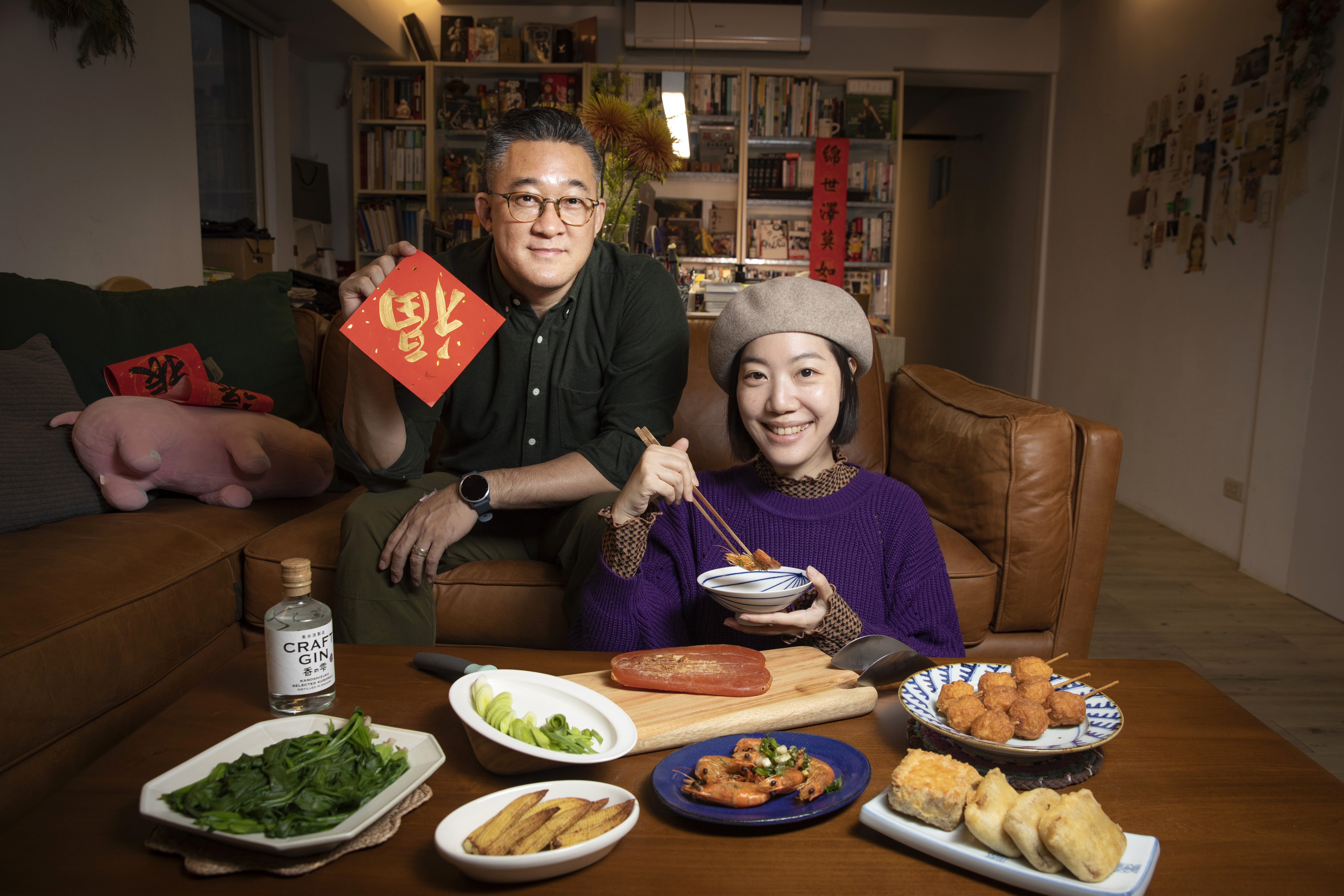 蘇瑜棻在家為我們演示高雄老家過年必備的烏魚子，先生協助提春聯。