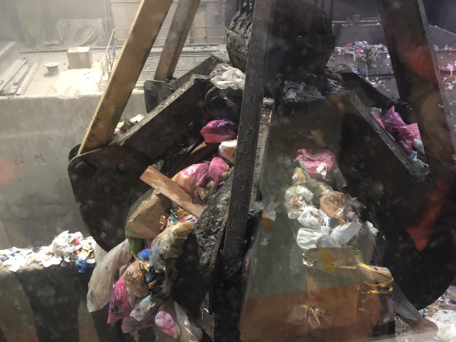 焚化廠員工操作機具將毒品送進焚化爐內銷毀。（翻攝畫面）