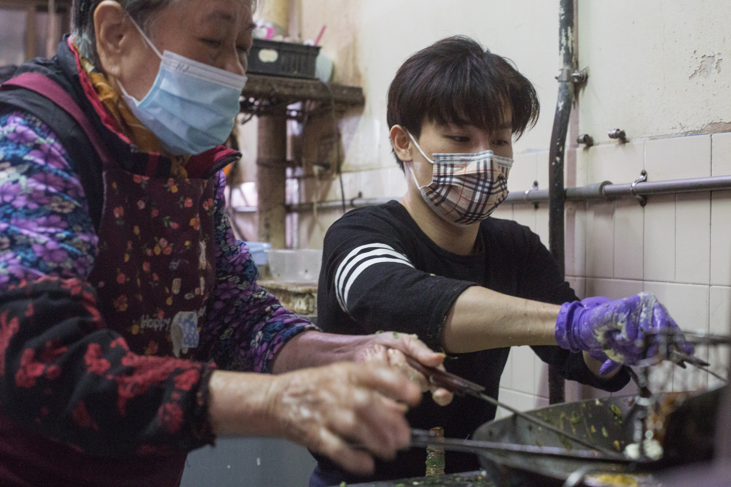 許凱綸（右）曾是職業撞球選手，不捨84歲的阿嬤林玉霞（左），2年前放棄18年撞球生涯，返家幫忙炸粿生意。