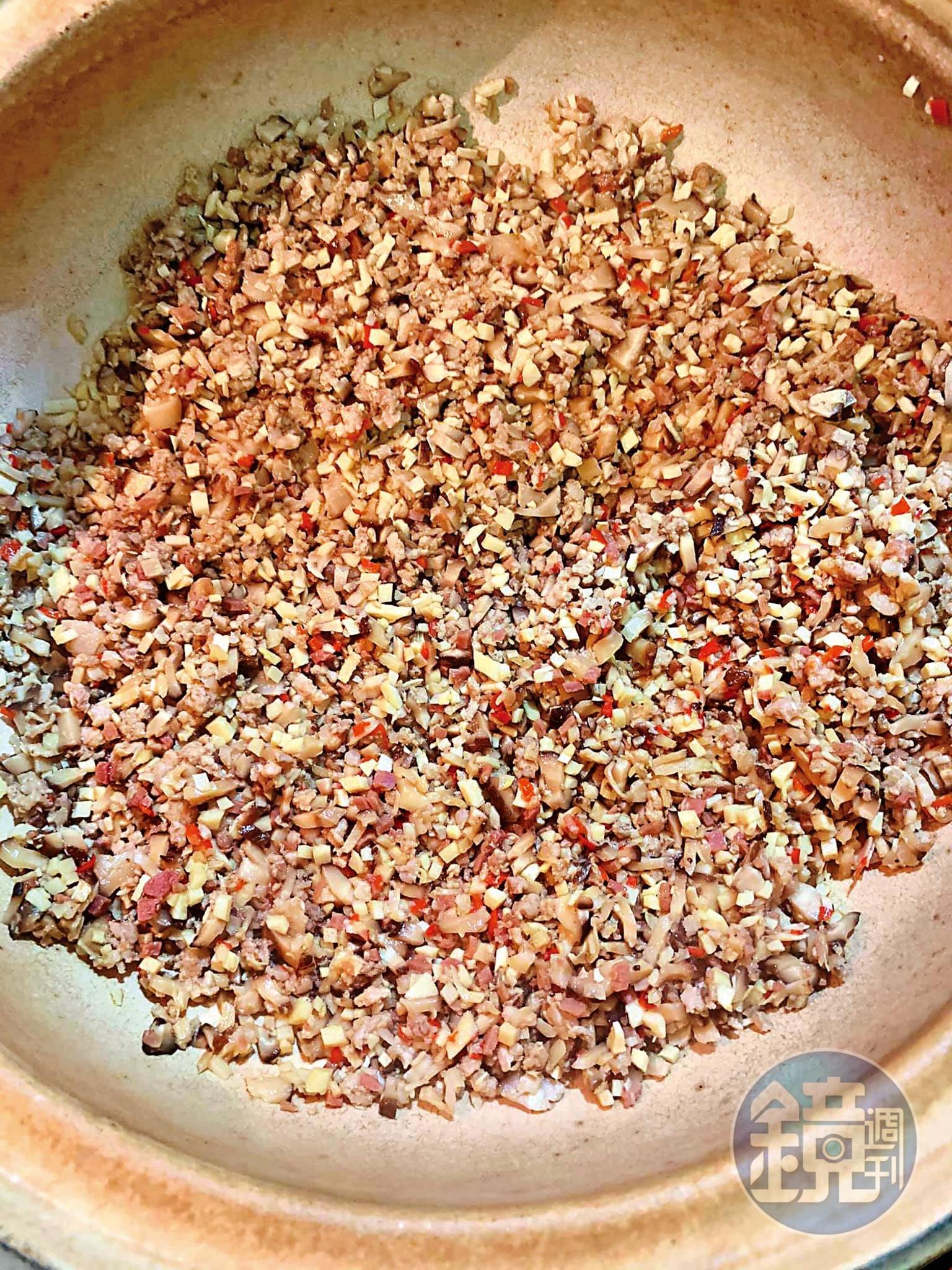 起油鍋炒香蒜末、辣椒末、絞肉、冬筍丁、香菇丁及火腿丁。