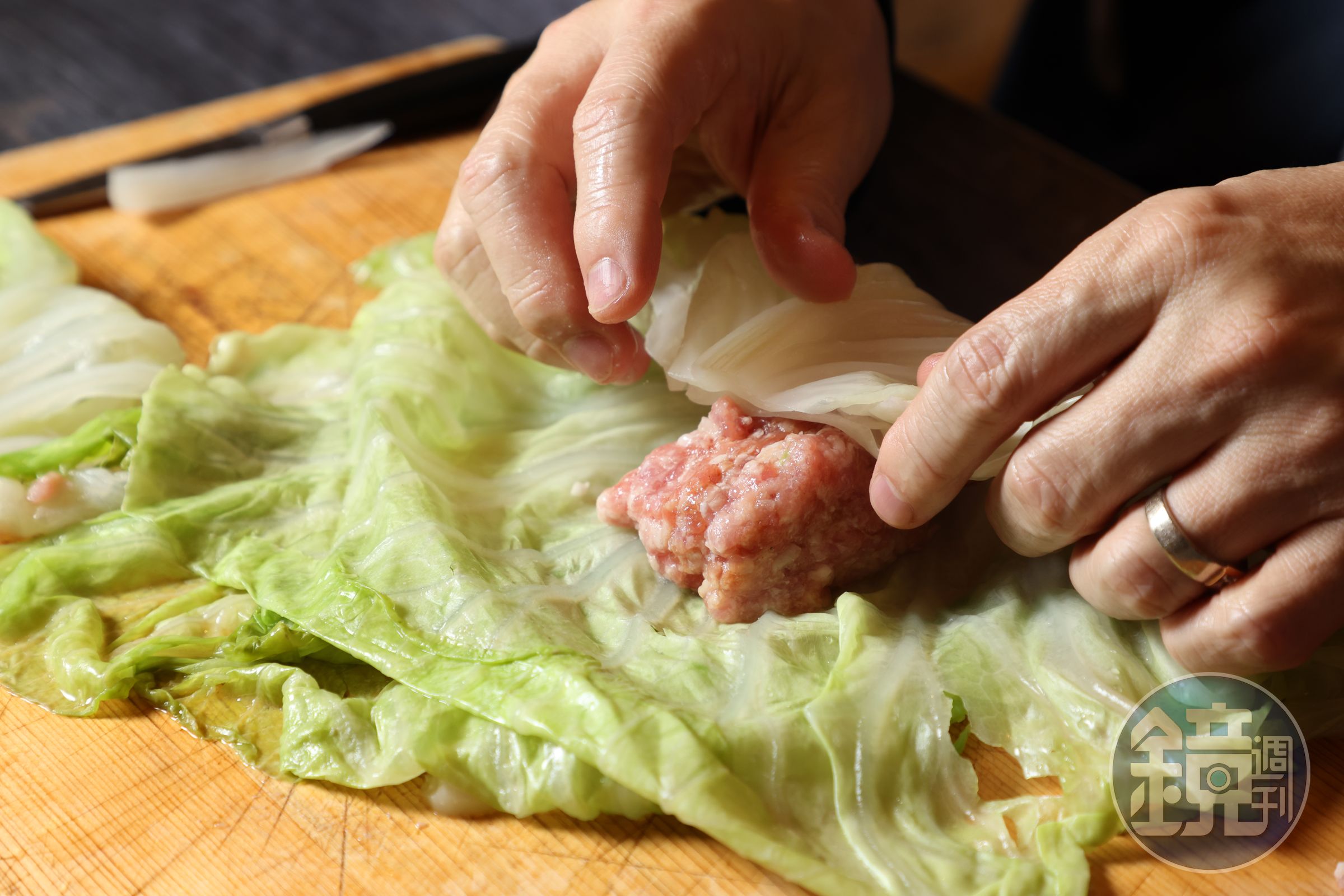 將絞肉放在2片高麗菜中，一邊折起。