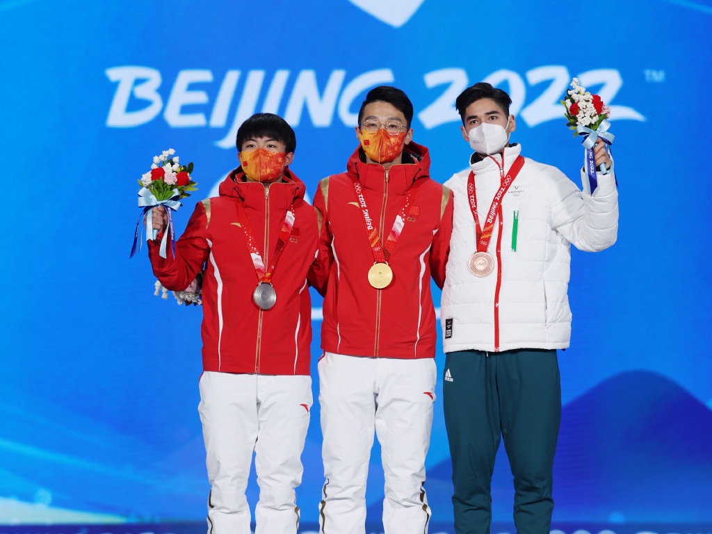 中國選手任子威（中）和李文龍（左）日前在冬奧男子短道速滑1,000公尺項目包辦金銀獎牌。（翻攝自2022北京冬奧年會微博）