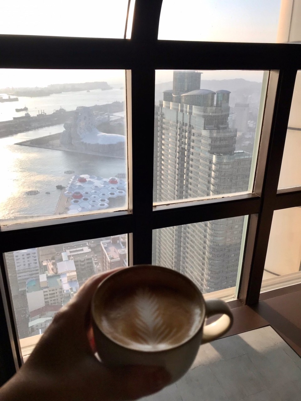 中午用餐結束居然已經夕陽斜映，我忍不住端了咖啡在窗邊欣賞黃昏的高雄港。