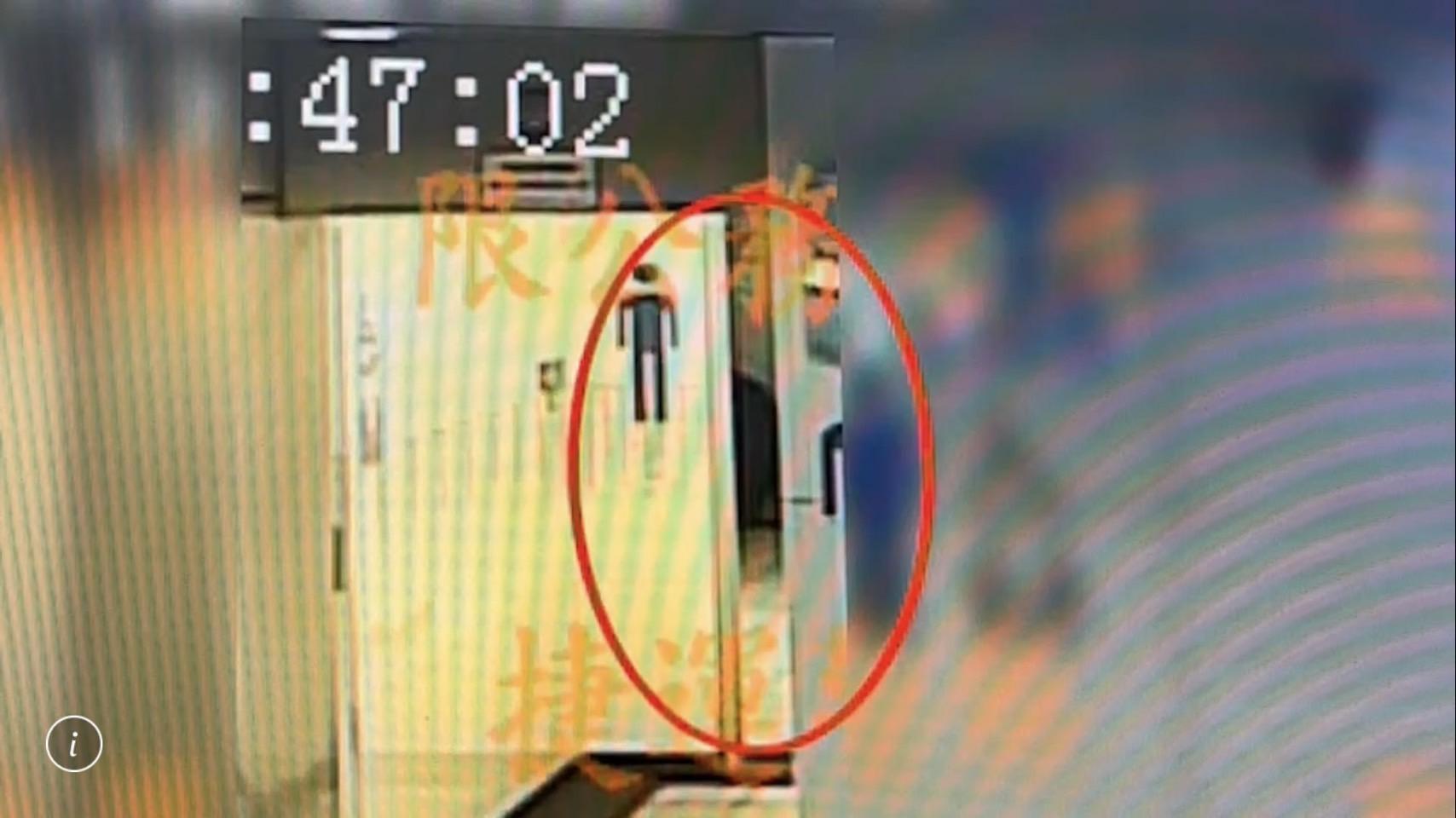 王男在南京三民站男廁內將手機伸進廁間偷拍。（翻攝畫面）