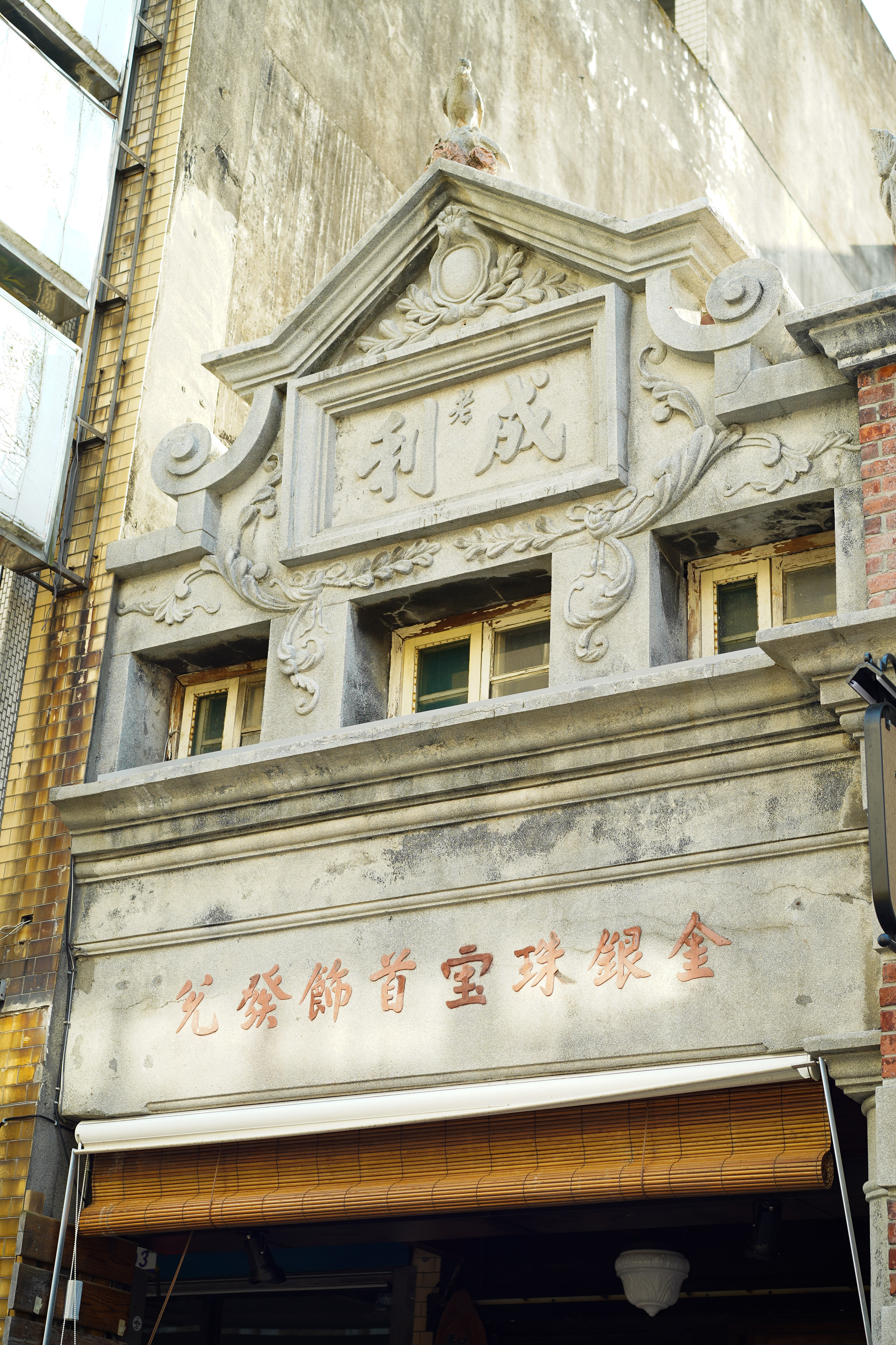 老成利興建於1886年，外頭牌樓浮雕為老鷹，象徵英雄獨立。	