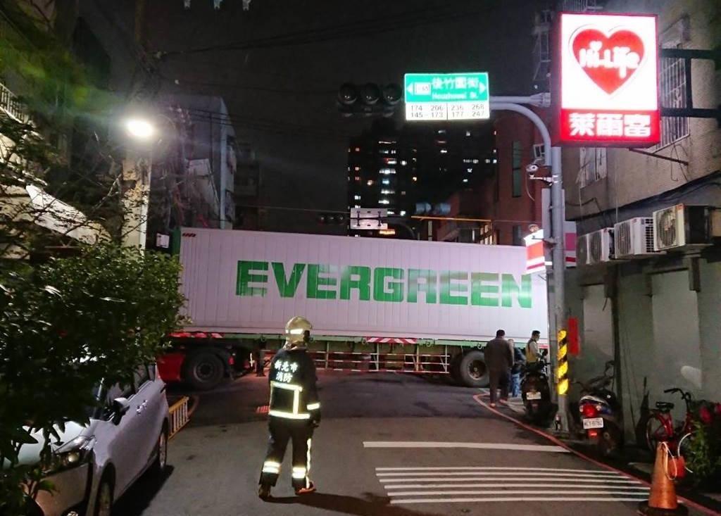 長榮貨櫃車的駕駛疑似不熟三重路況,開進窄巷未注意到限高,導致貨櫃車頂部勾到電線桿電纜卡死。(翻攝畫面)
