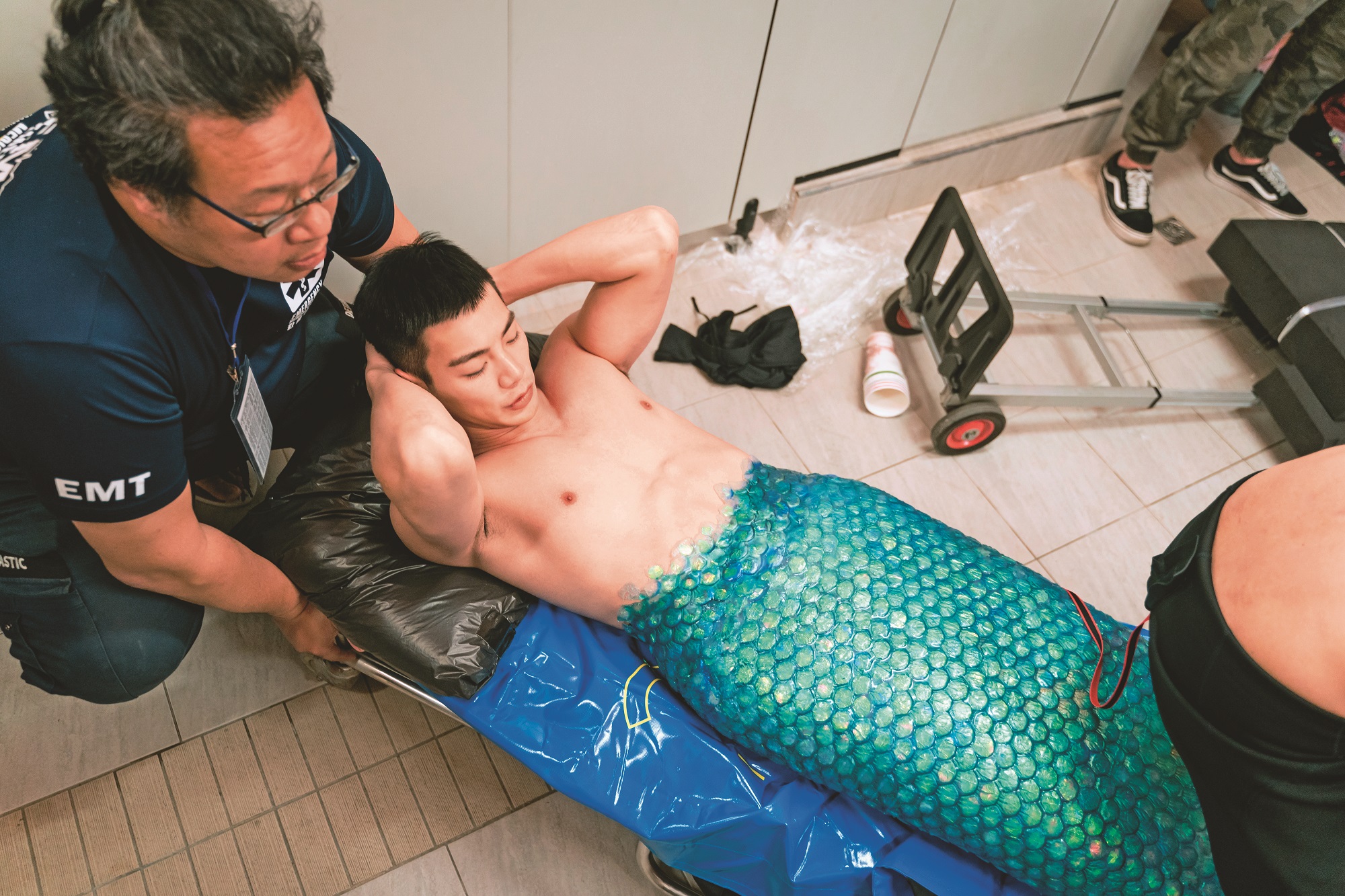 禾浩辰吃力穿上重達30公斤的矽膠魚尾後,還得由工作人員搬運至拍攝位置。(羚邦集團提供)
