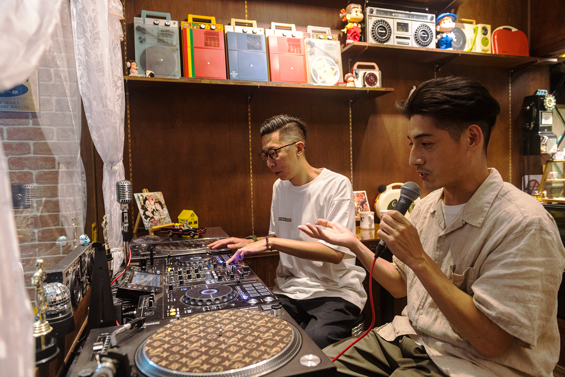 咖啡館窗前的DJ台,是QQ(左)與Jimmy(右)錄製秋波電台節目的工作區。