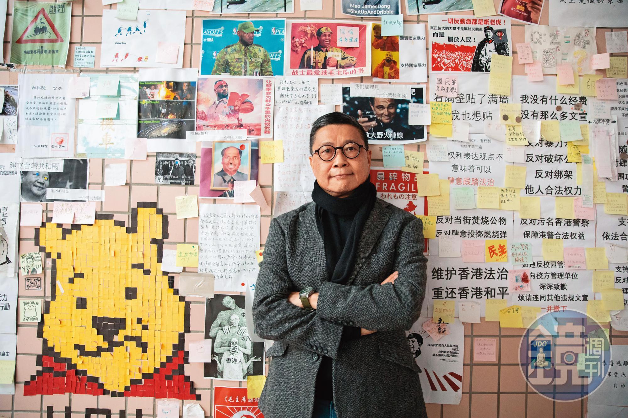 接受採訪這天，陳健民領我們到政大連儂牆前，他身後幾張簡體字樣，疑似是大陸學生對台港學生的嗆聲。