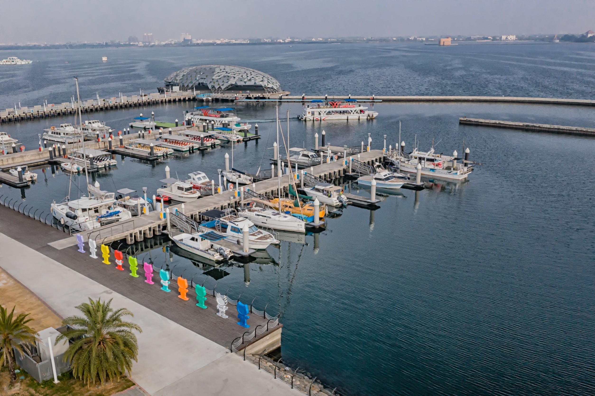 228假期來到大鵬灣，會發現遊艇碼頭邊多了一整排色彩繽紛的公仔，其中暗藏防癌意義。（癌症希望基金會提供）